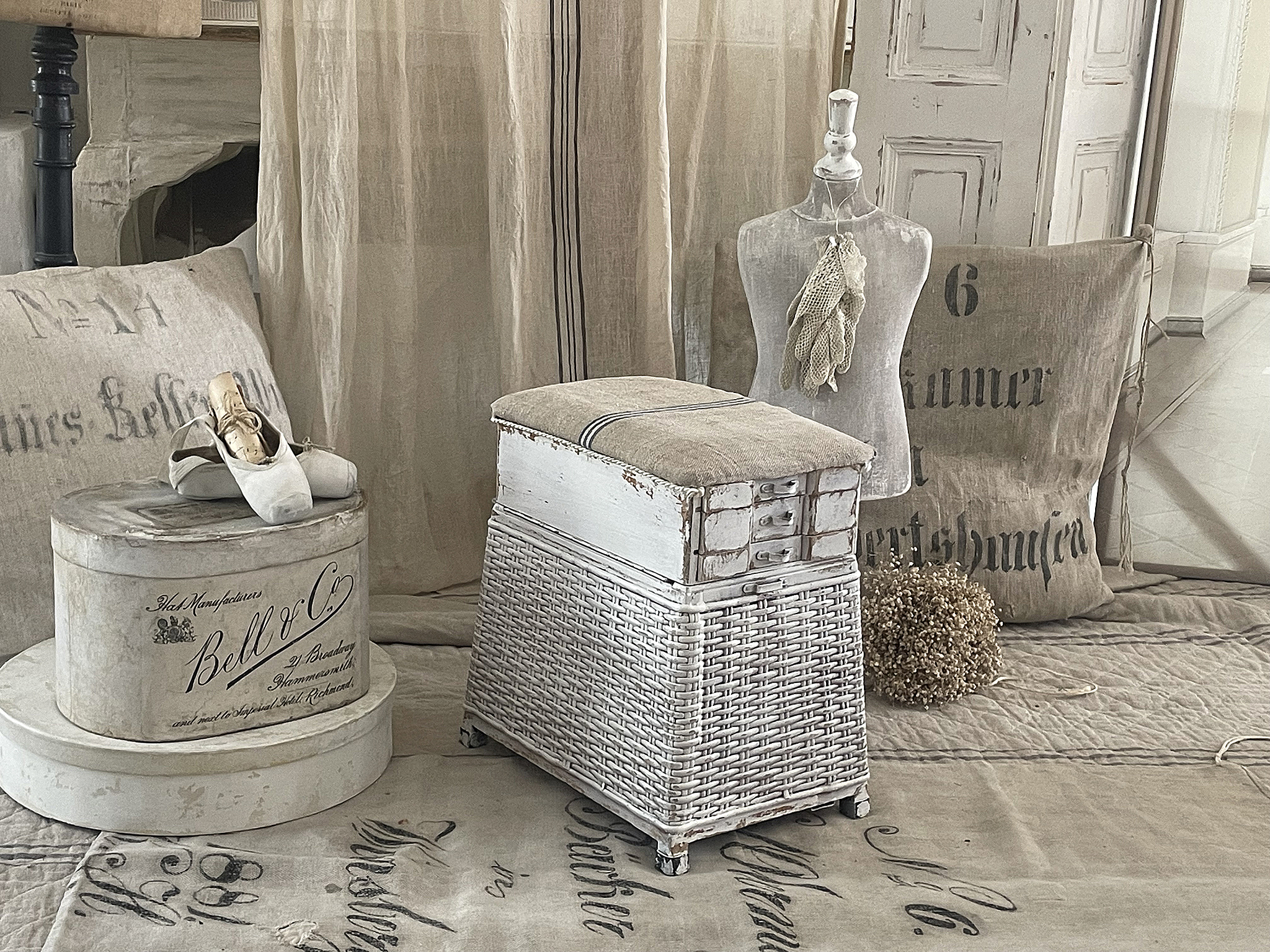 Eleganter vintage Hocker mit Aufbewahrung und Dekoration Ein stilvoller Hocker mit Platz für Stauraum, umgeben von dekorativen Gegenständen im skandinavischen Design.