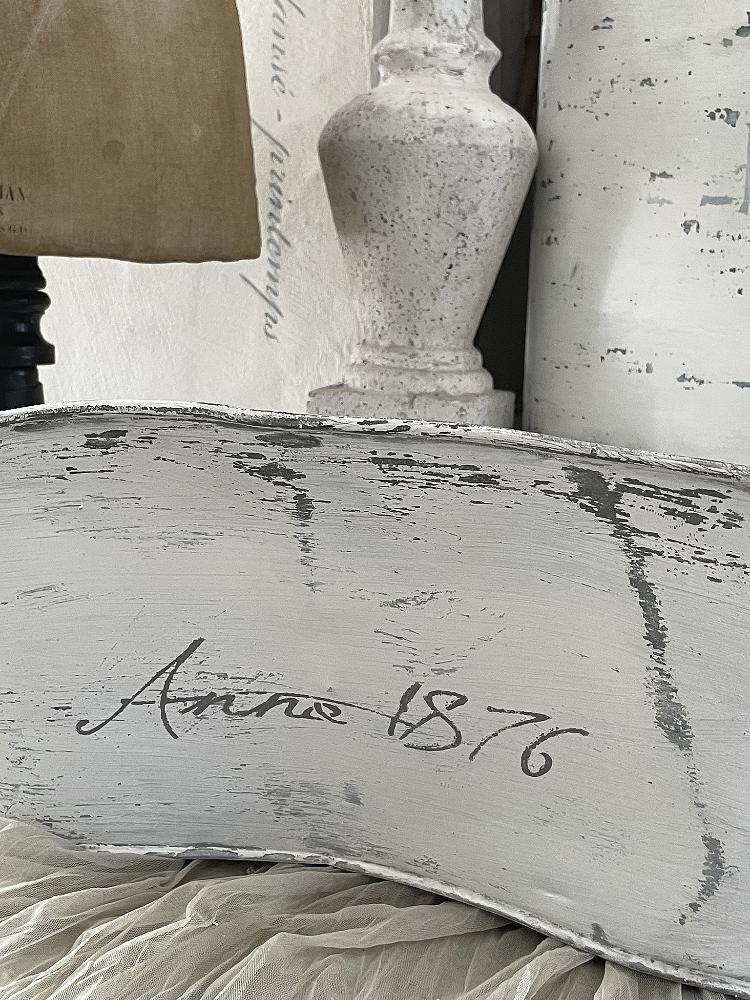 Dekorativer Vintage-Objekt mit der Aufschrift Annie 1876 Detailaufnahme eines vintage Dekorationsobjekts mit der Schrift Annie 1876 auf einer grauen Oberfläche.
