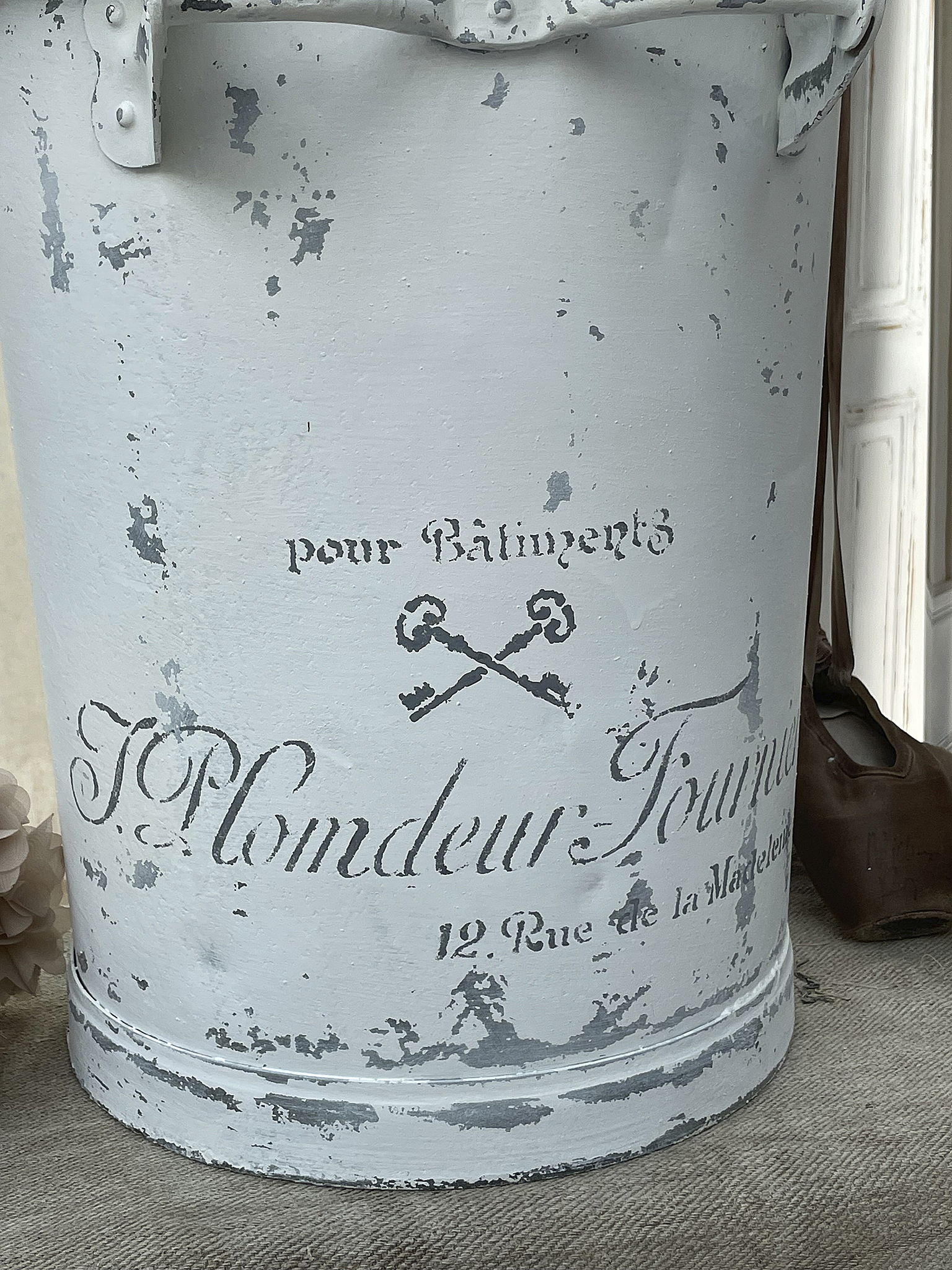 Vintage Eimer mit dekorativem Aufdruck Dekorativer Eimer mit grafischem Design und Schriftzug auf antik wirkendem Hintergrund