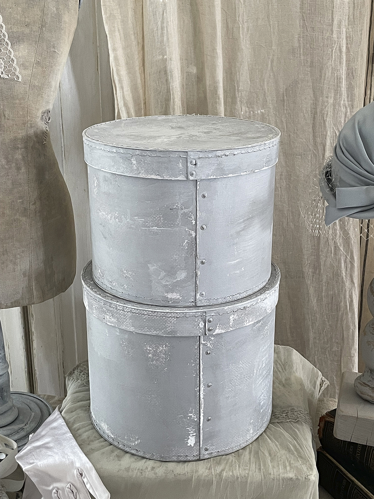 Dekorative graue Aufbewahrungsgläser im vintage Stil Zwei graue dekorative Aufbewahrungsgläser aus Metall, übereinander gestapelt, auf einem Tisch.