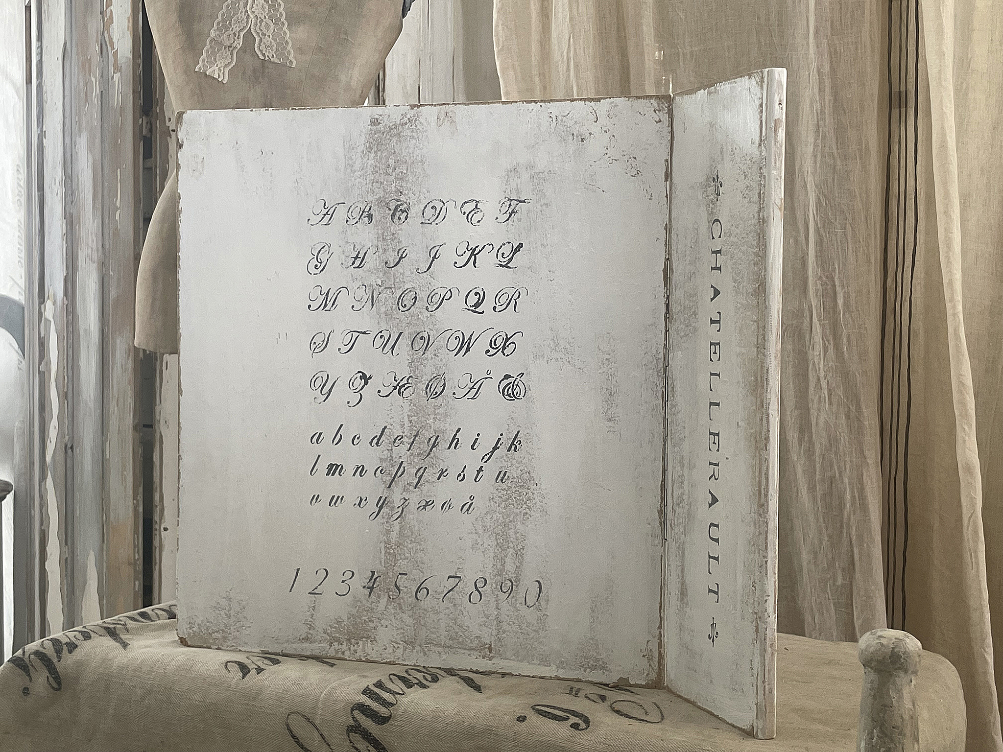 Antike Alphabettafel mit kunstvoller Beschriftung und Zahlen auf einem hellen Hintergrund