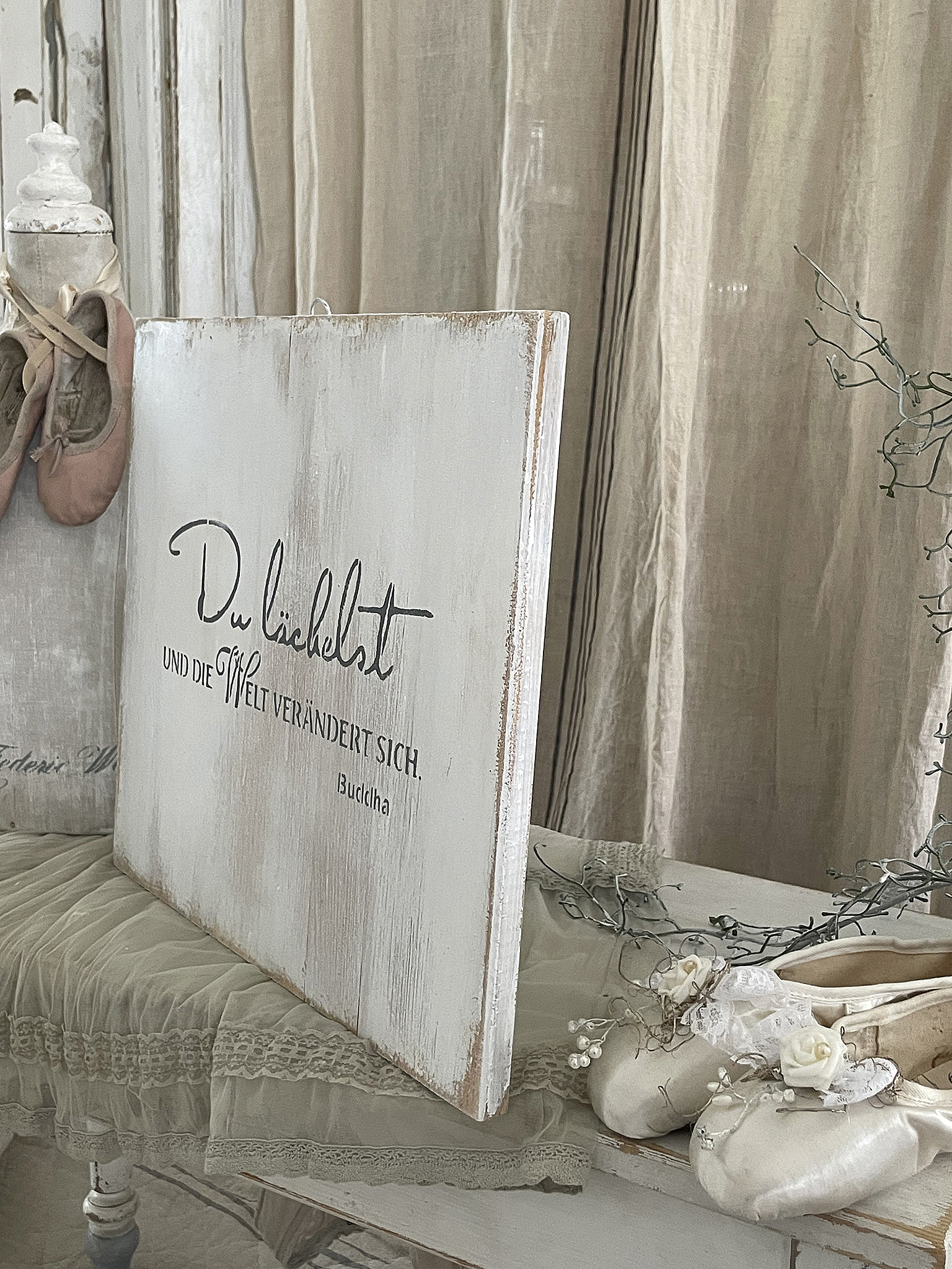 Dekoratives Holzschild mit dem Text 'Du liebst und die Welt verändert sich.'