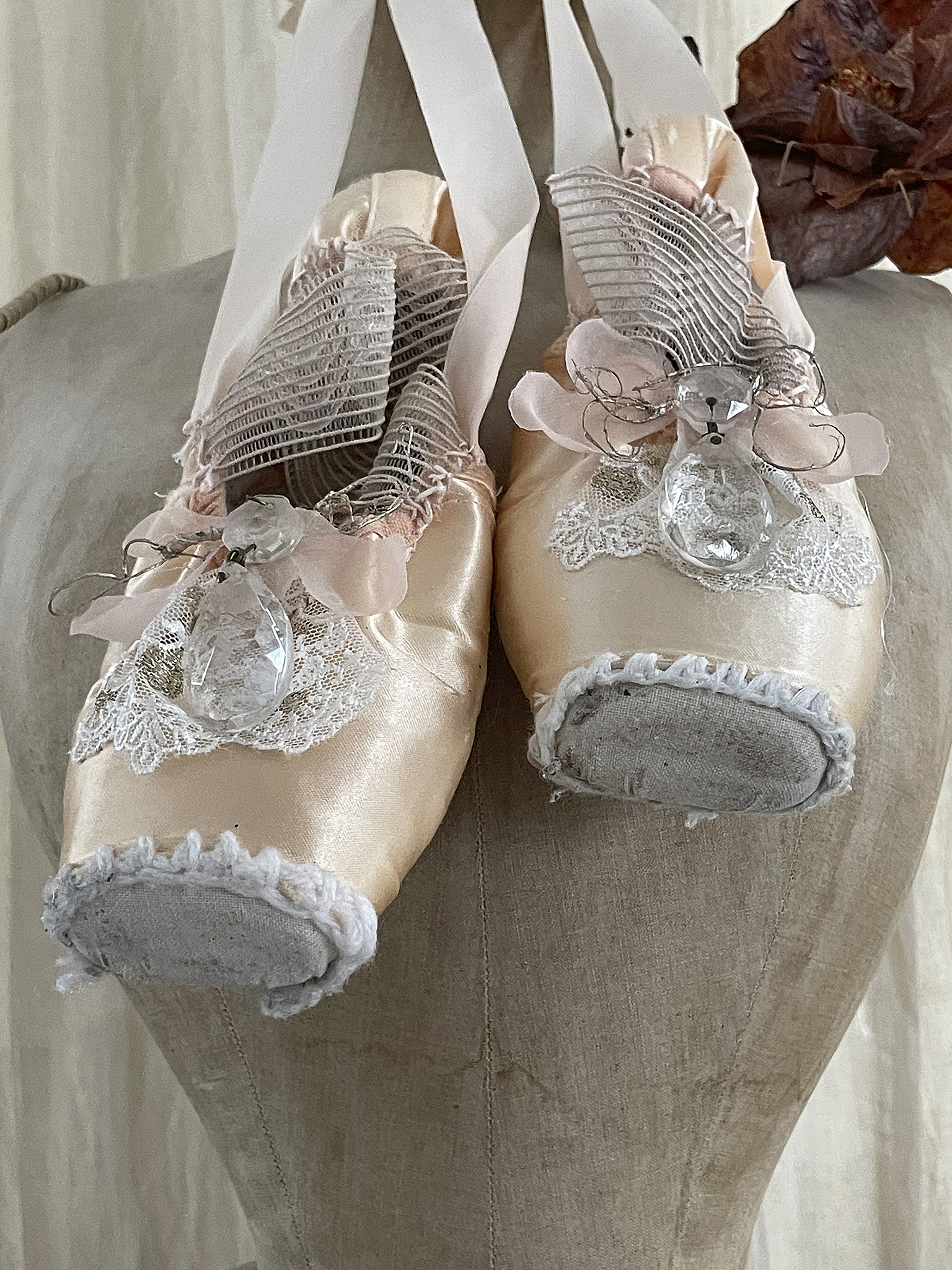 Elegante Ballettschuhe mit zartem Design und Schmuckverzierung Dekorative Ballettschuhe auf einer Puppe, ausgestattet mit Ripsband und feiner Spitzenverzierung.