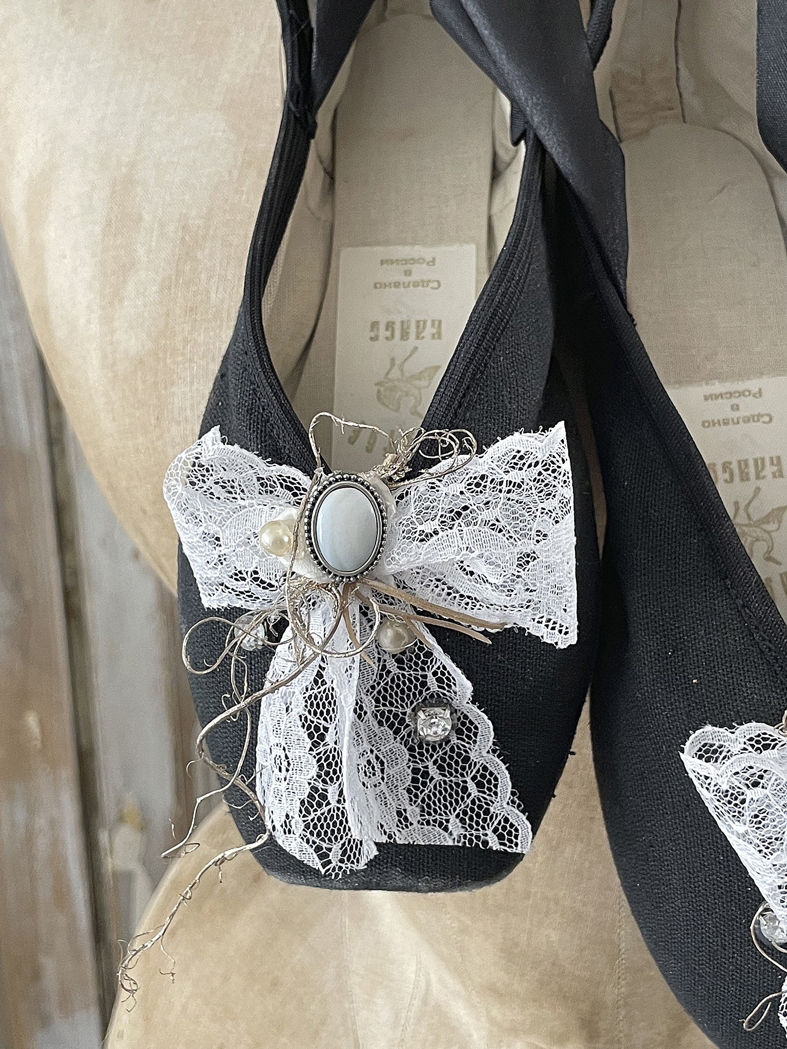 Elegante schwarze Schuhe mit Spitzenverzierung und Dekoration Schwarze Schuhe mit einem weißen Spitzenband und dekorativen Elementen