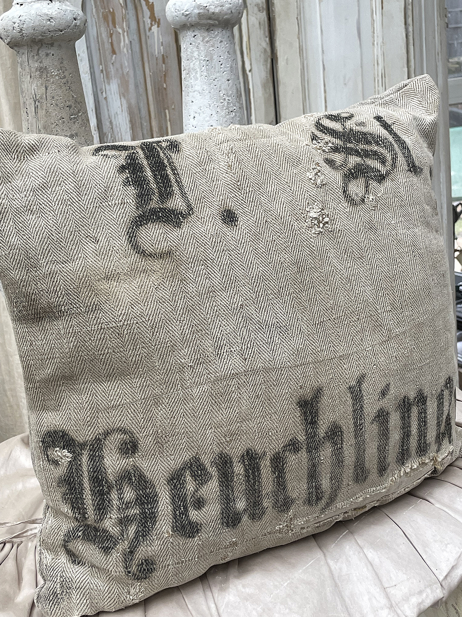 Dekoratives Kissen mit Vintage-Druck Kissen aus Stoff mit einem vintage-inspirierten Druck, auf einem neutralen Hintergrund platziert.