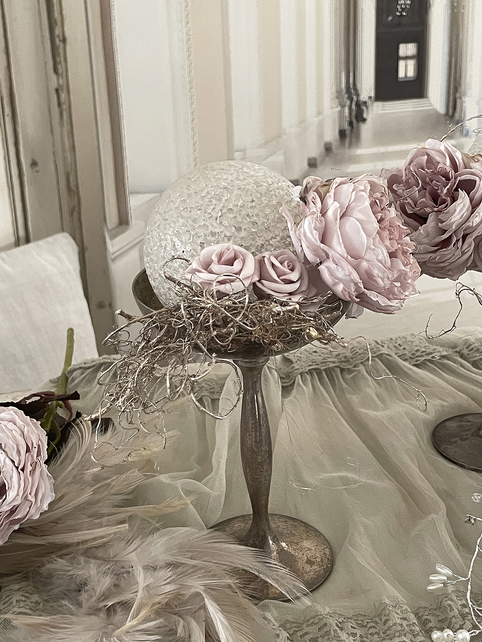 Elegante Tischdekoration mit Rosen und dekorativem Glasobjekt Schöne Tischdeko mit rosa Rosen, einer Glas Kugel und feinem Tuch