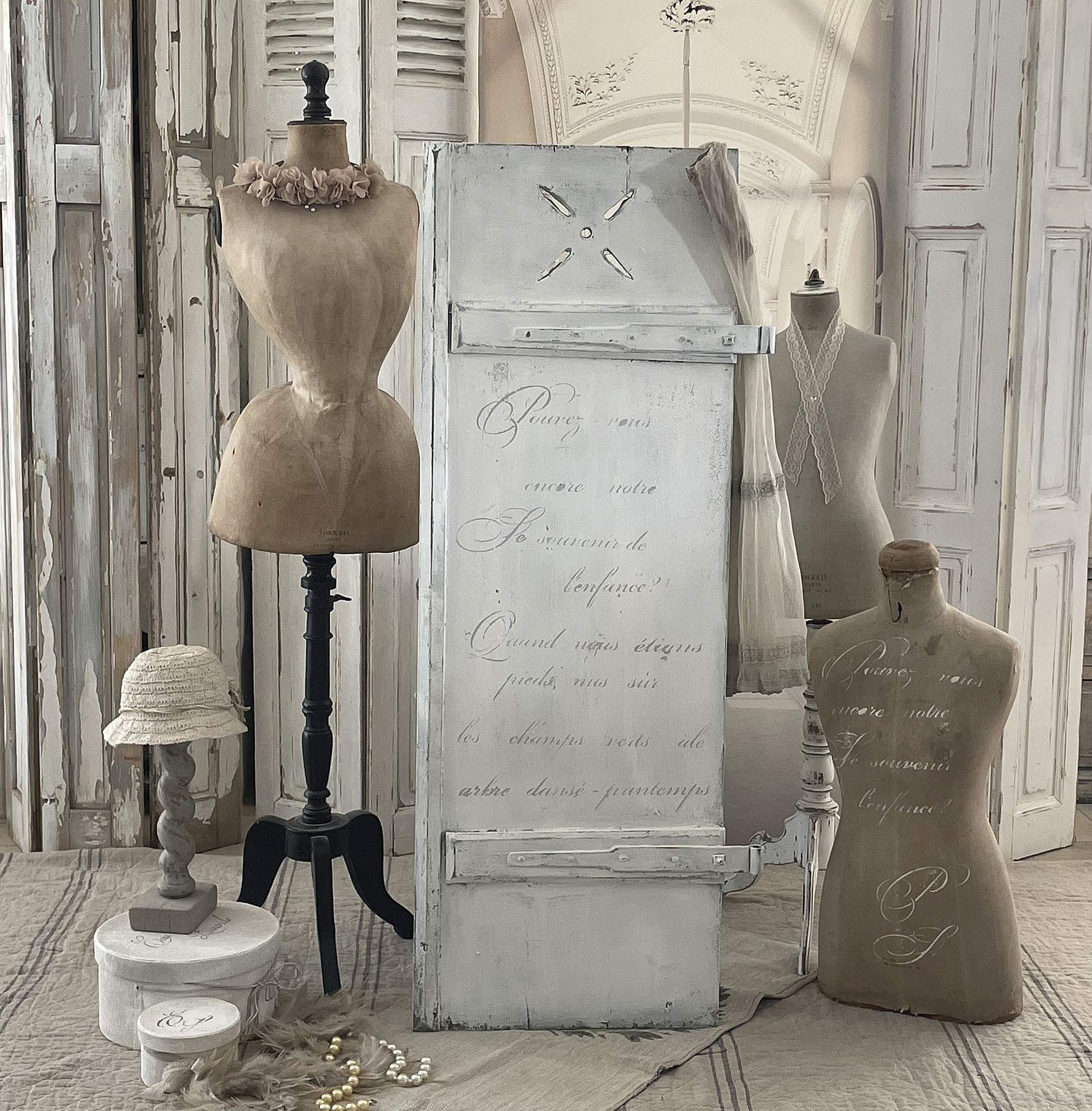 Dekoratives Interieur mit Schneiderpuppen, antikem Möbelstück und stilvollen Accessoires