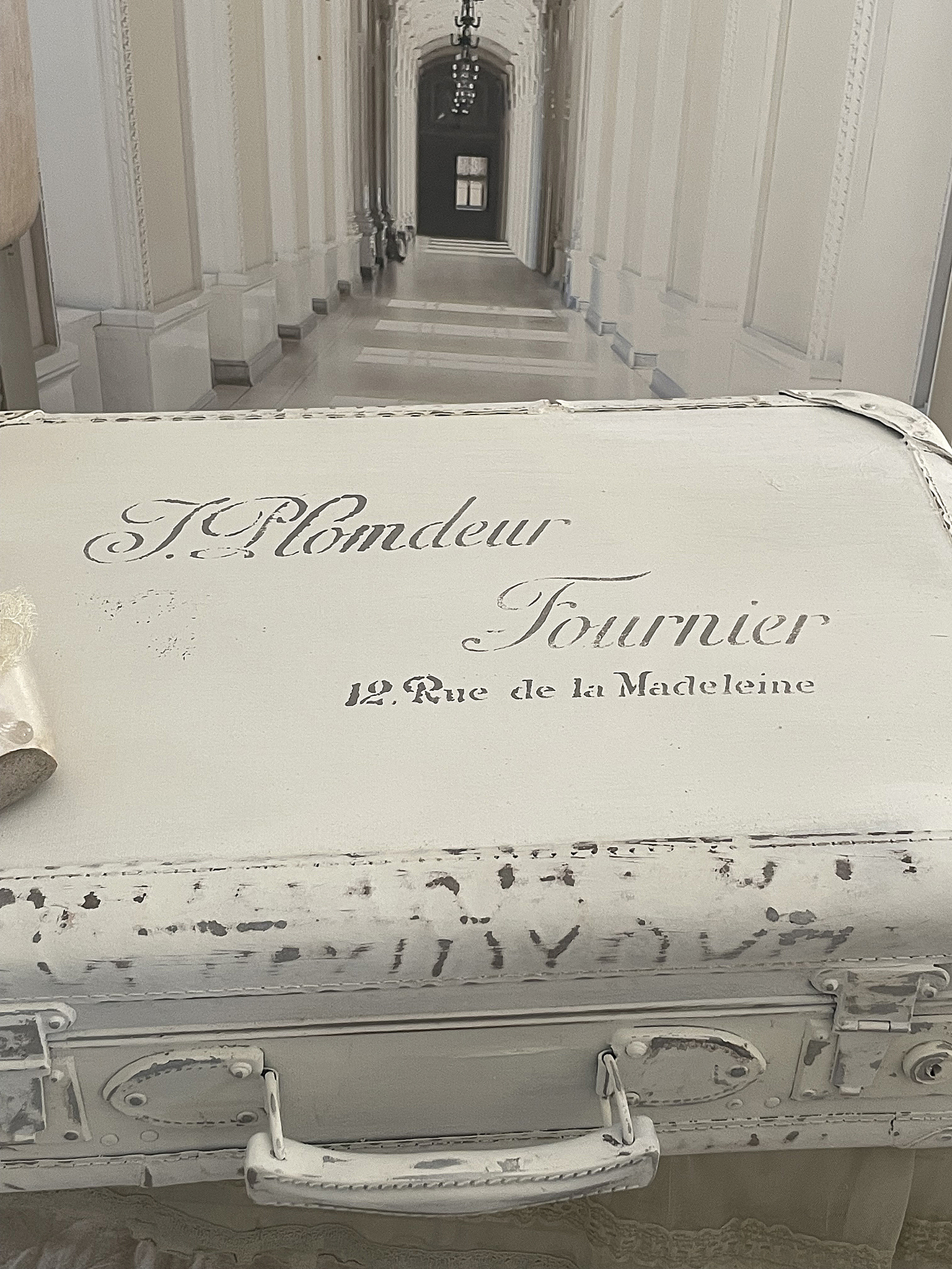Vintage Koffer mit Schriftzug von J. Plondeur Fournier, 12 Rue de la Madeleine Antiker Koffer mit eleganten Details und nostalgischem Schriftzug in einem hellen Interieur
