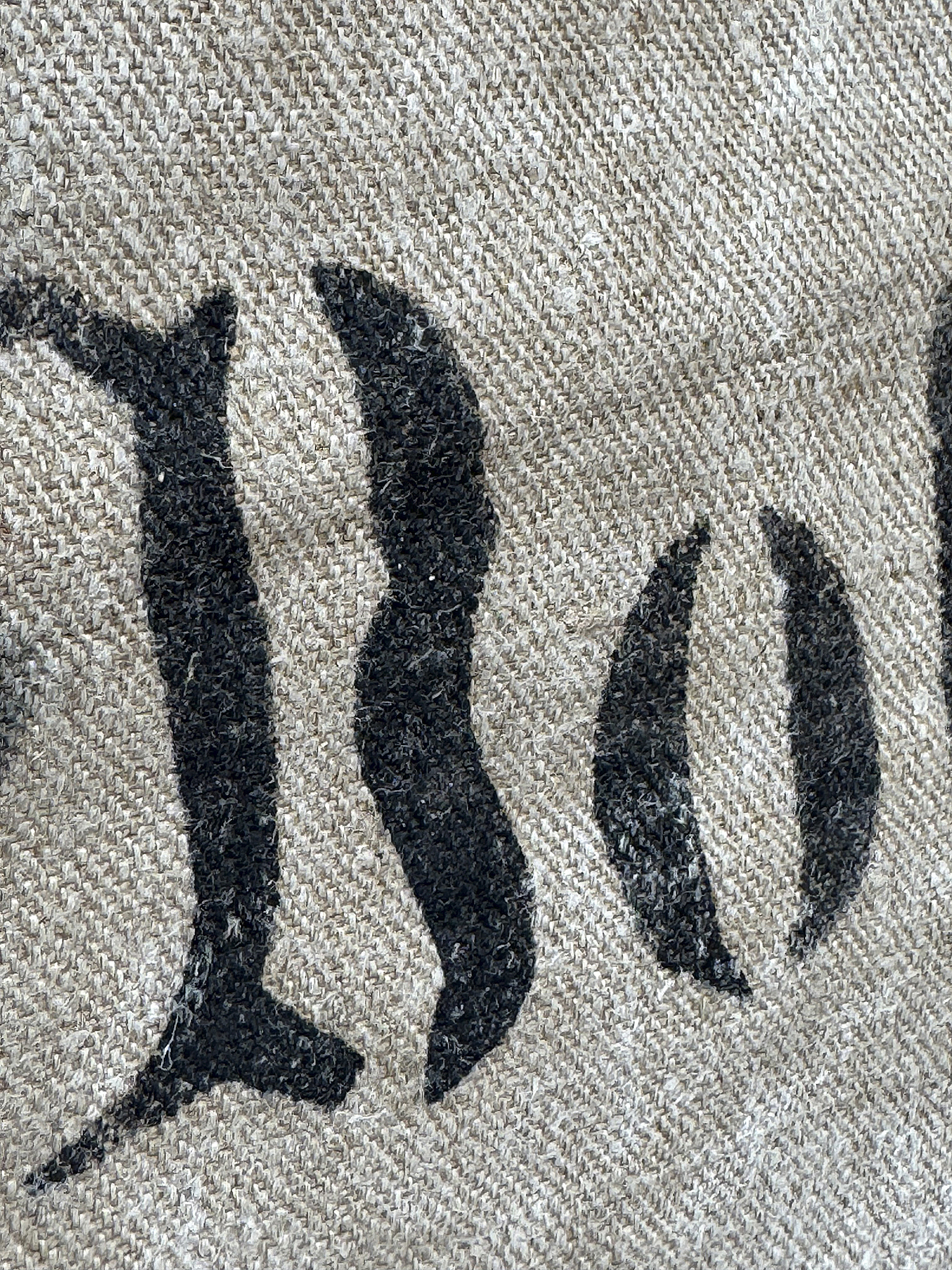 Detailansicht eines textilem Materials mit Schwarzschrift Nahaufnahme eines gewebten Stoffes mit schwarzen Buchstaben