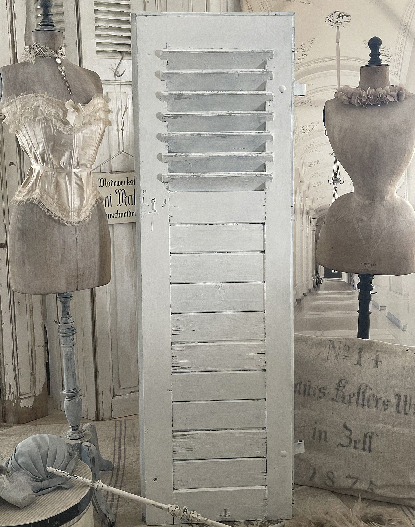 Antiker Holzladen mit Vintage-Kleidern und Dekoration Ein antiker Holzladen steht neben vintage Kleiderpuppen in einem stilvollen Raum.
