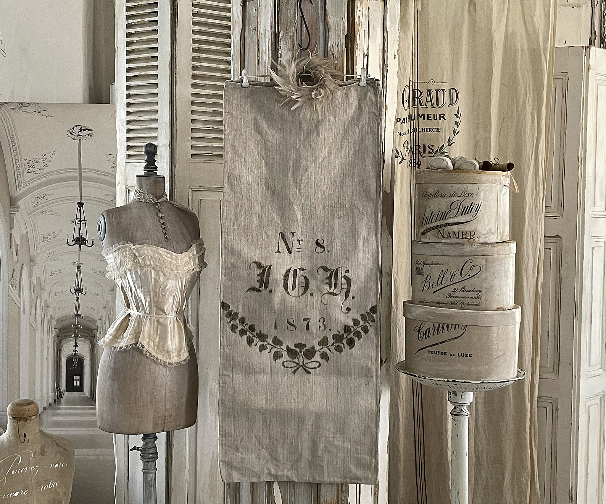 Ein stilvolles Mannequin in nostalgischer Umgebung mit einem Stoffbanner und dekorativen Boxen.