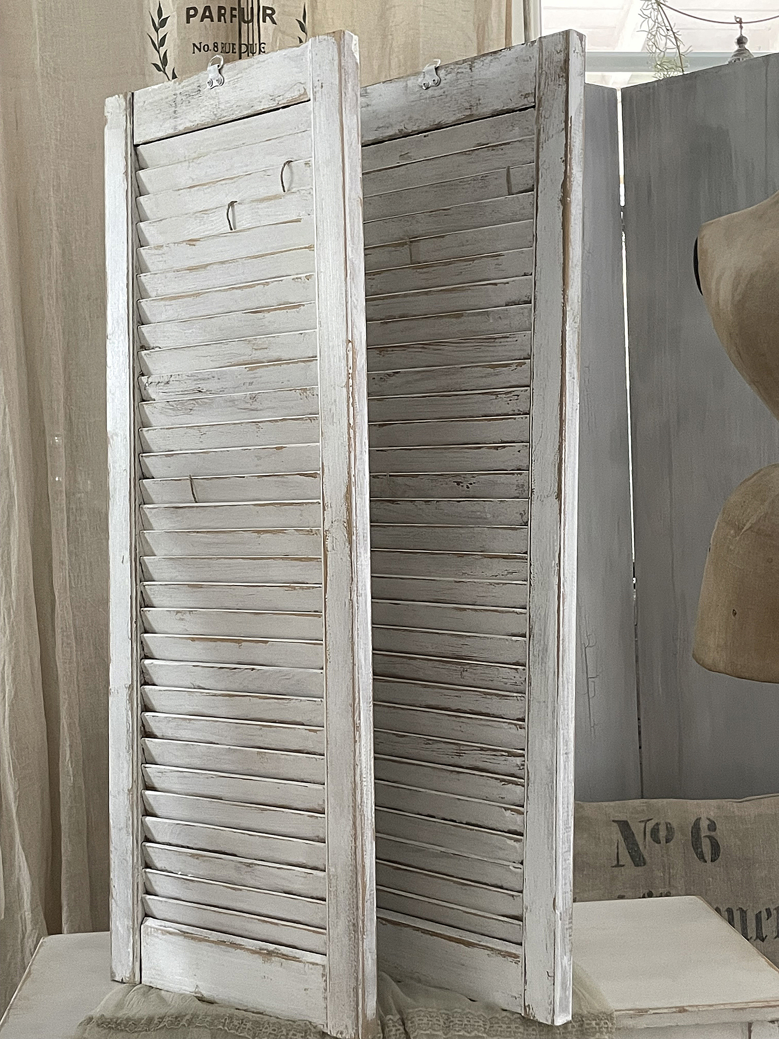 Dekorativer weißer Raumteiler im Shabby-Chic-Stil Schöner weißer Raumteiler aus Holz mit Lamellen und Vintage-Charme
