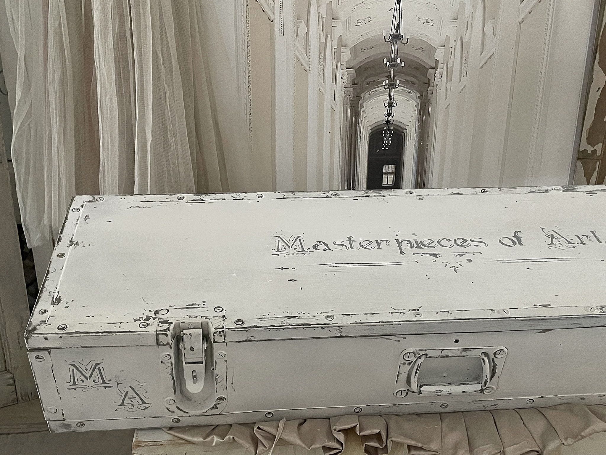 Weisse, antike Kiste mit dekorativen Elementen und der Inschrift 'Masterpieces of Art'