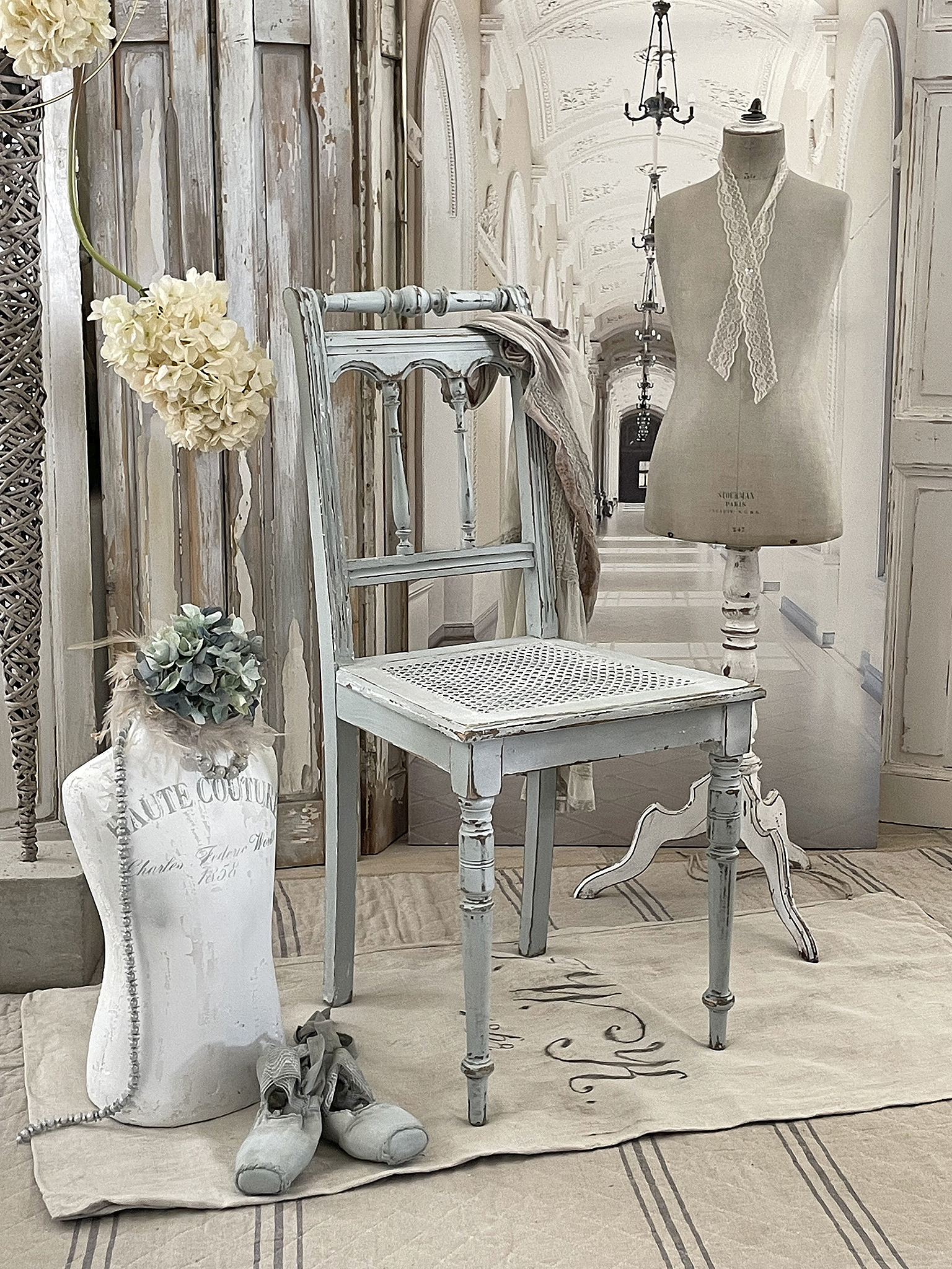 Eleganter Shabby Chic Stuhl mit Dekoration in einem stilvollen Raum Shabby Chic Stuhl und Mannequin in einem geschmackvoll dekorierten Raum