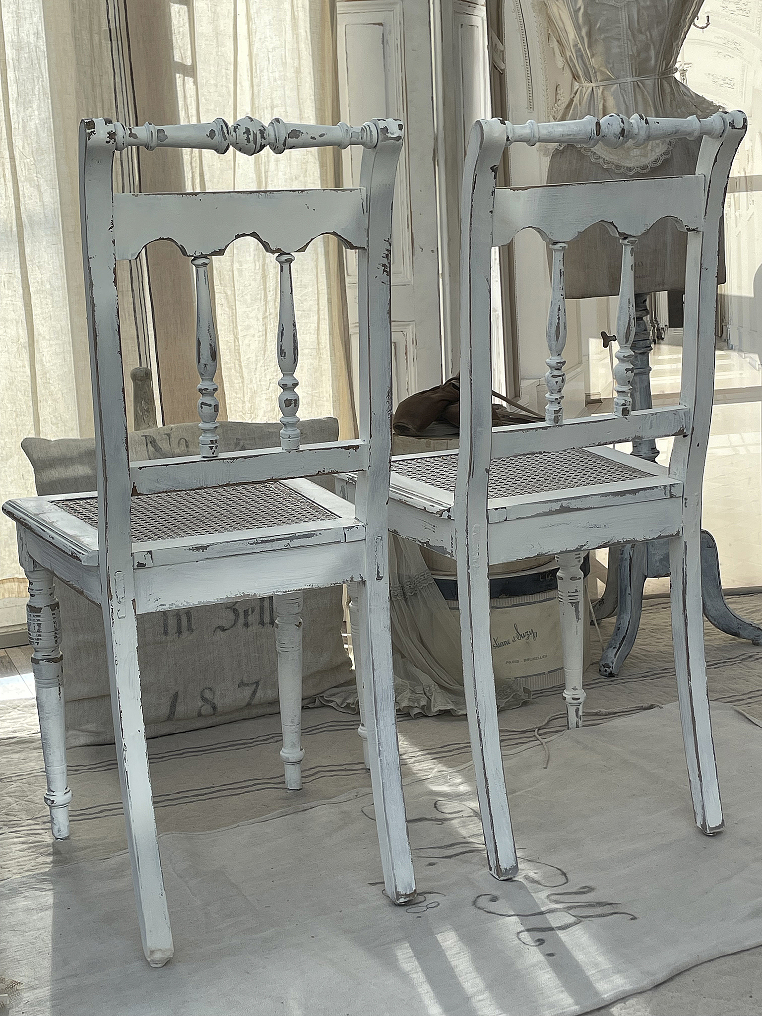 Zwei antike Stühle aus Holz im Shabby-Chic-Stil, in weißer Farbe mit abgeschabtem Lack.