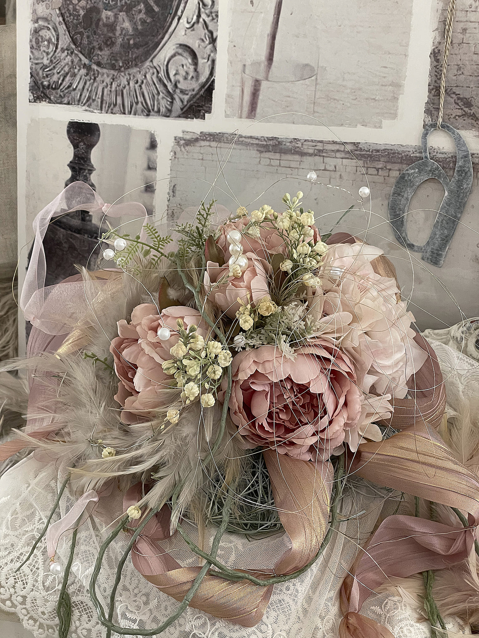 Wunderschöner Blumenschmuck mit rosa und weißen Blumen Dekorativer Blumenstrauß mit rosa Blüten, Federn und zarten Deko-Elementen