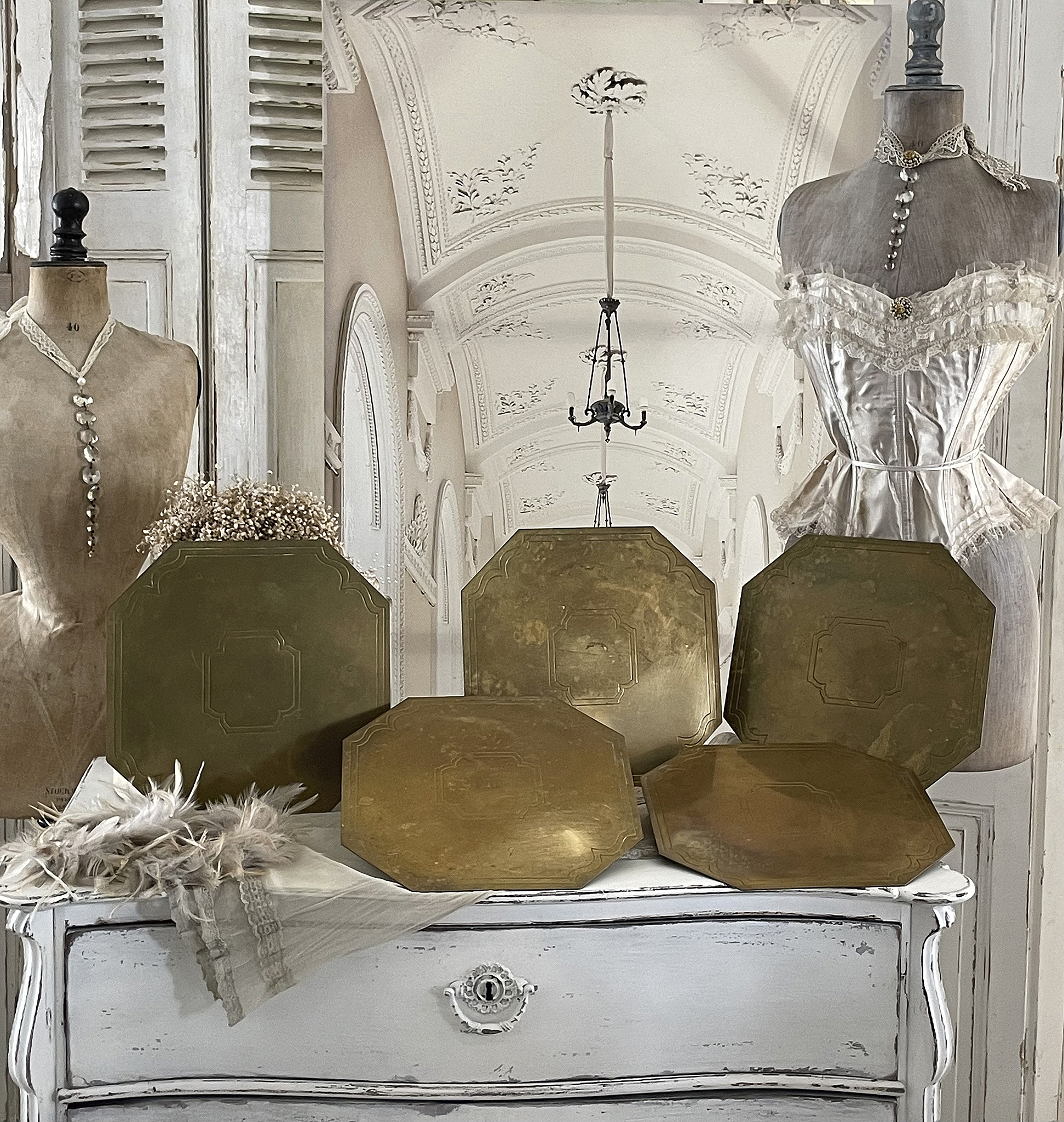 Elegante antike Platten in einem stilvollen Interieur Antike Messingplatten auf einem weißen Kommode mit modischen Accessoires