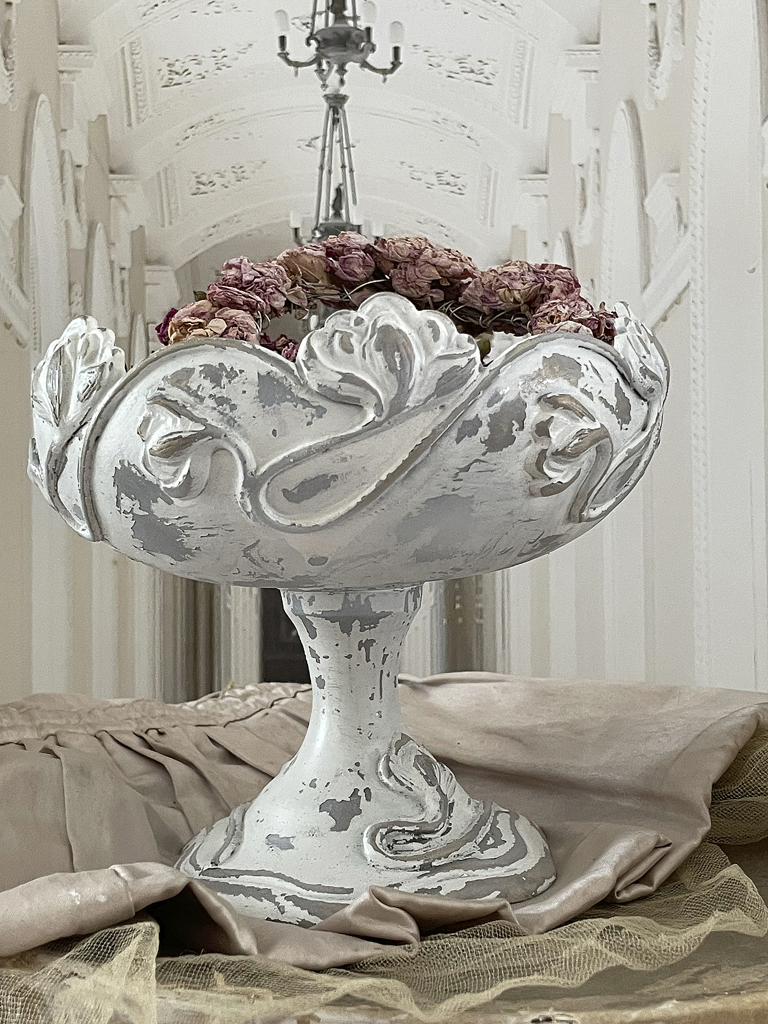Dekorativer Blumentopf mit getrockneten Rosen Eleganter Blumentopf aus weißem Material mit Rosendekoration, abgestellt auf einem sanften Untergrund