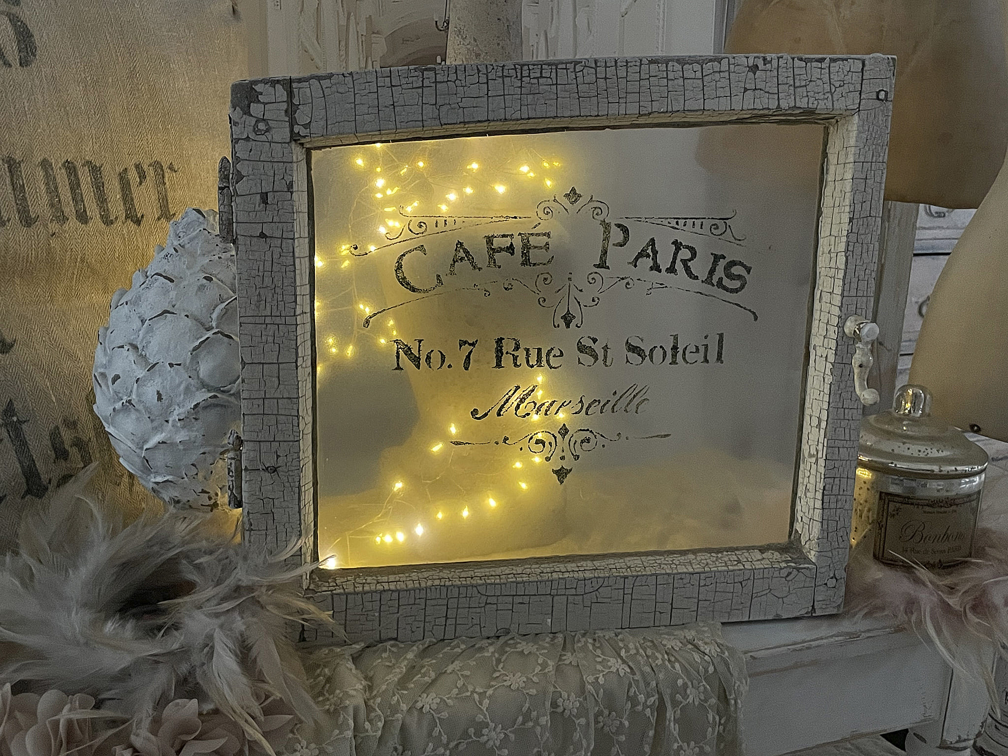 Dekorativer Vintage-Rahmen mit Café Paris Beschriftung und warmen Lichtern