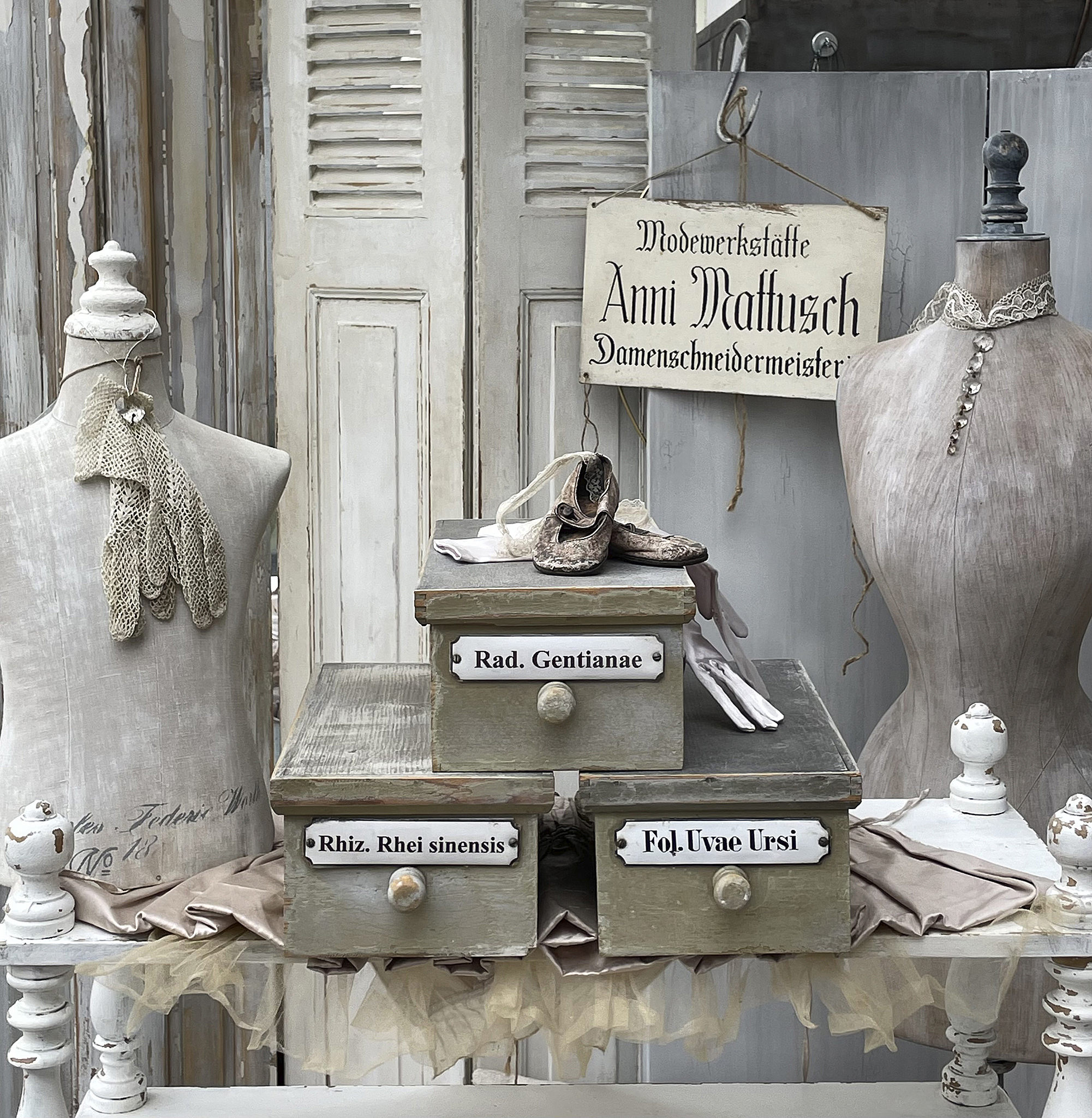 Antike Schneiderwerkstatt mit Schaufensterpuppen und Requisiten Detailansicht einer Modewerkstatt mit Schaufensterpuppen, Antiquitäten und Aufbewahrungskästen