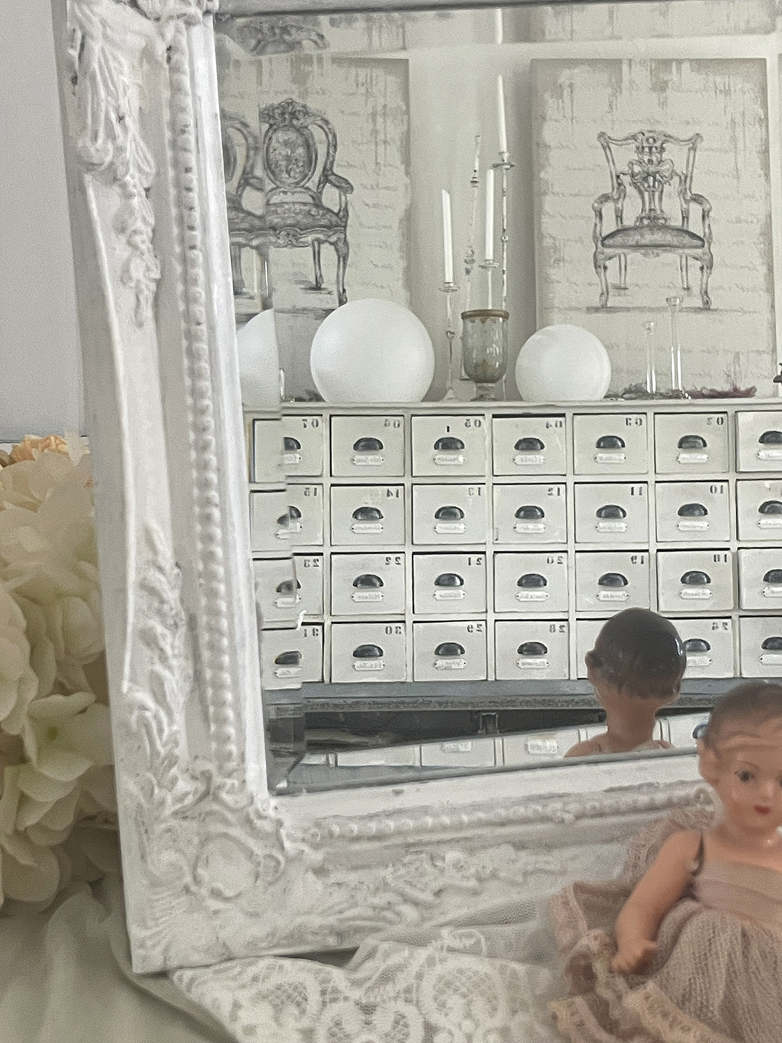 Antiker Spiegel mit nostalgischer Puppe und stilvollem Interieur Antiker Rahmen spiegelnd eine nostalgische Puppe und dekorative Objekte im Hintergrund