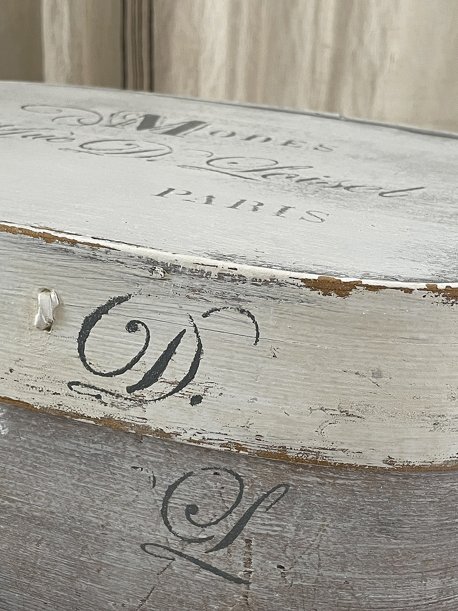 Detailaufnahme einer antiken Holzkiste mit dem Schriftzug "Modes D. Paris"
