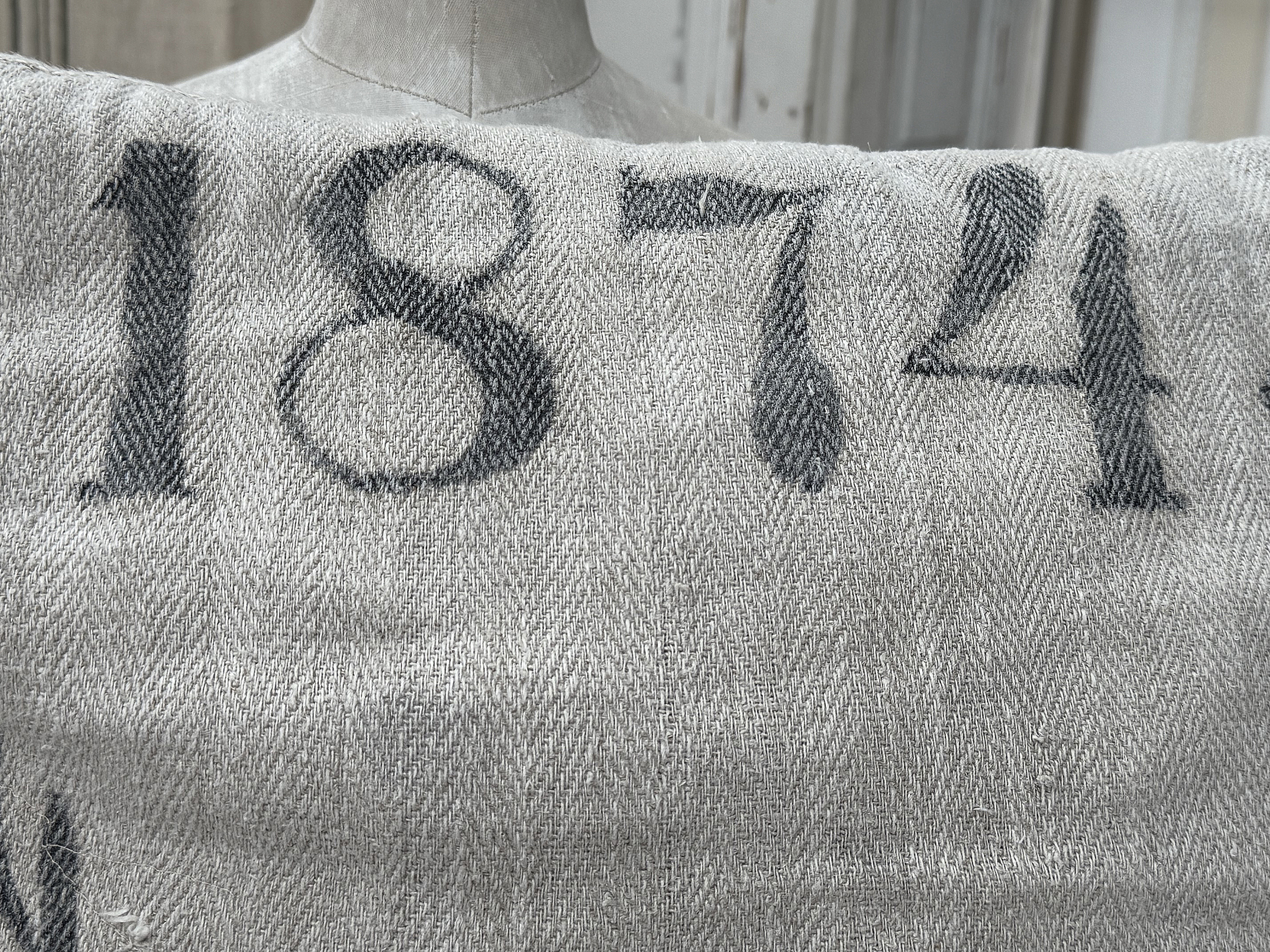 Historischer Stoff mit der Nummer 1874 für kreative Projekte Detailansicht eines grauen Stoffes mit der Aufschrift 1874