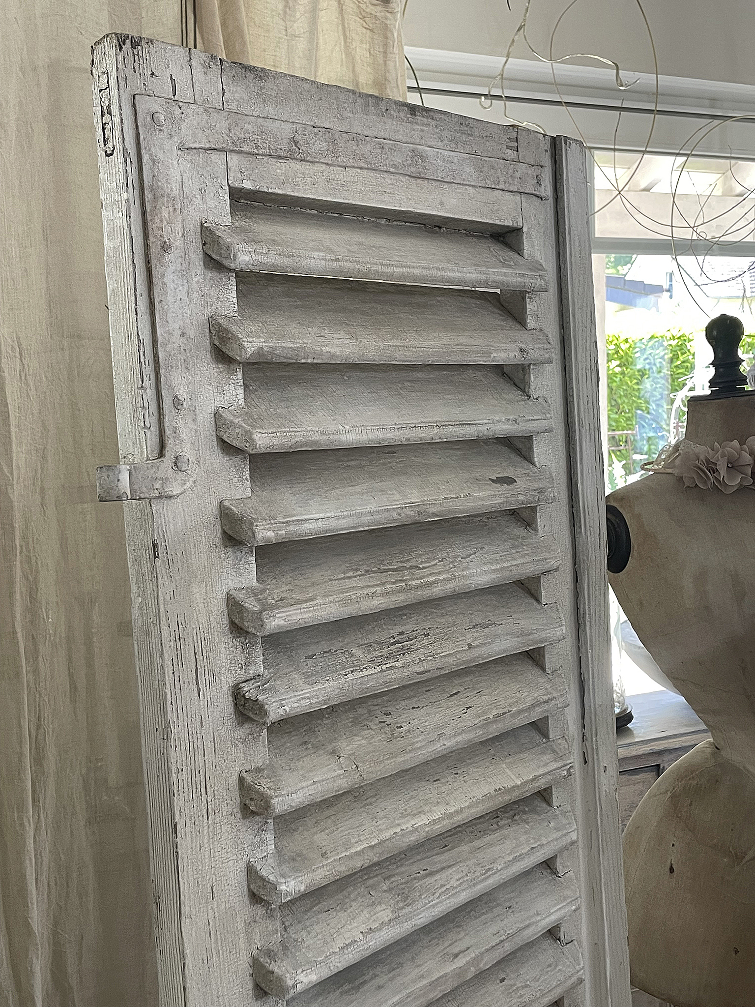 Antike Fensterläden in sanftem Weißton Detailansicht einer antiken Fensterlade mit Struktur und Patina