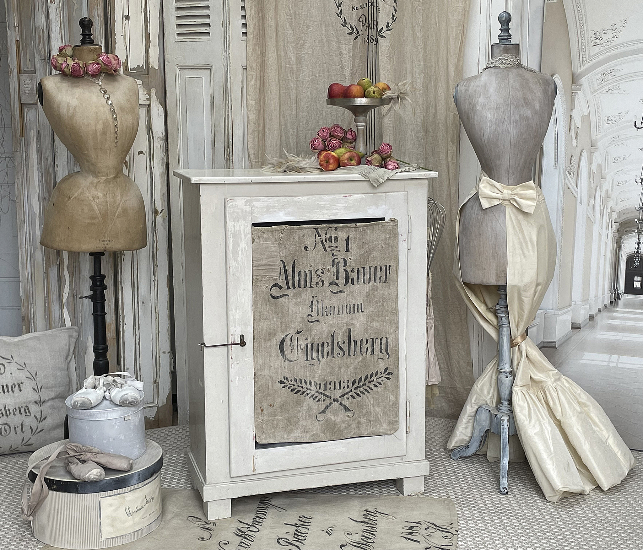 Vintage Möbelstück mit Schneiderpuppen und Dekoration Dekoratives Arrangement mit einem Möbelstück, Schneiderpuppen und Blumen.
