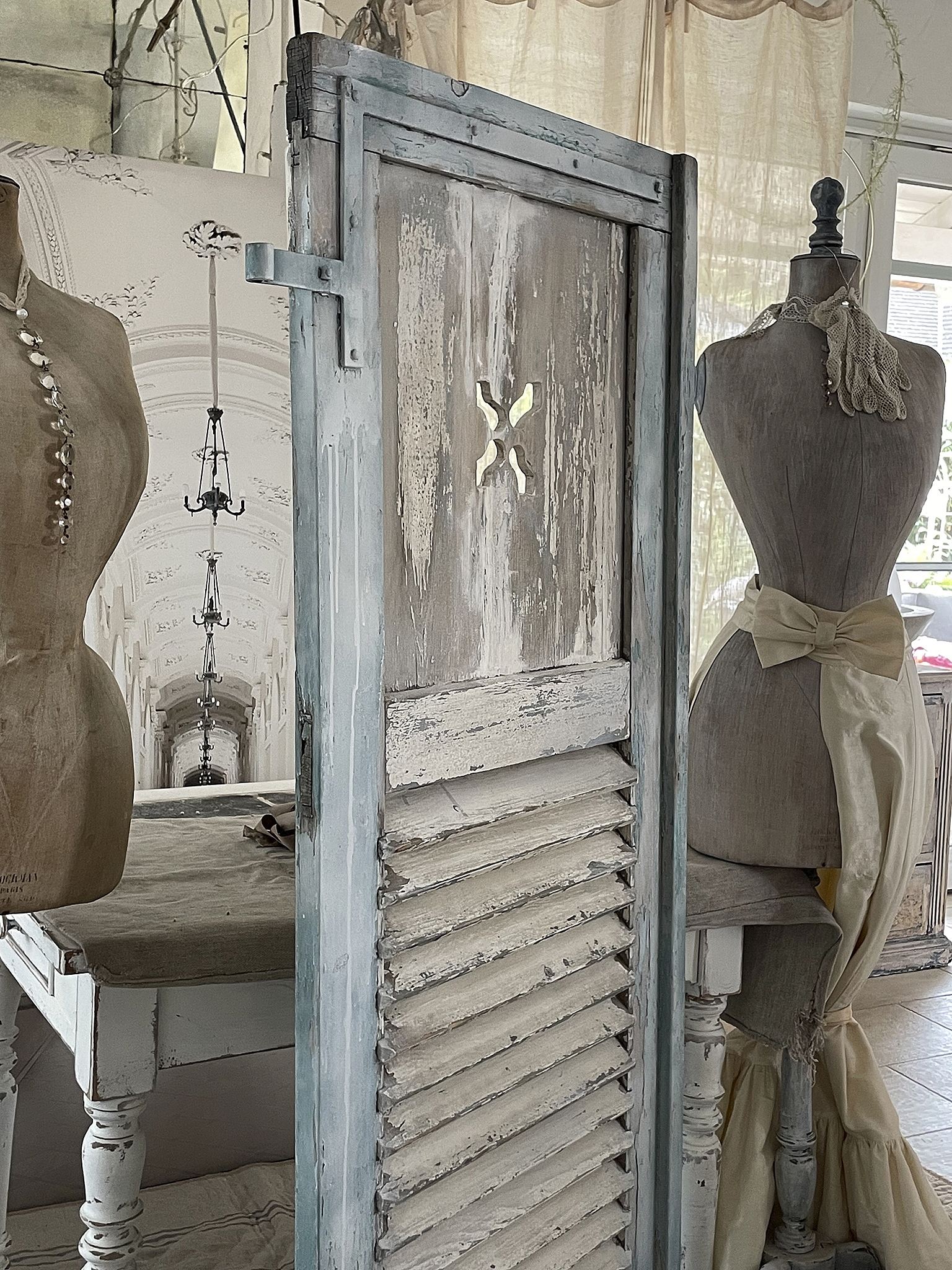 Vintage Holzschrank mit Shabby-Chic Design Detailansicht eines Vintage-Holzschranks im Shabby-Chic-Stil mit einer Schneiderpuppe im Hintergrund.