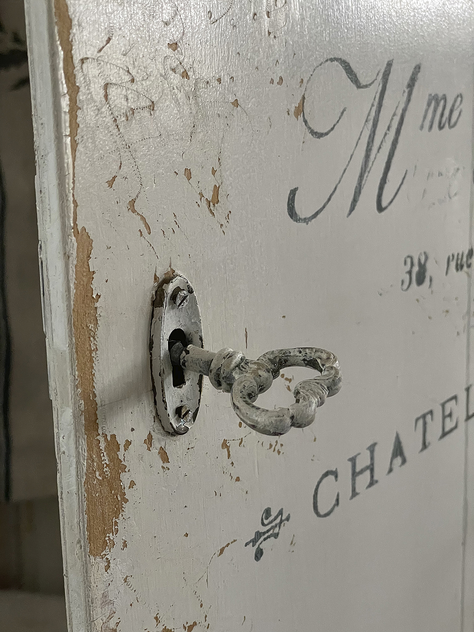 Detailaufnahme eines antiken Schlüssels in einer Holztür mit sichtbaren Gebrauchsspuren.