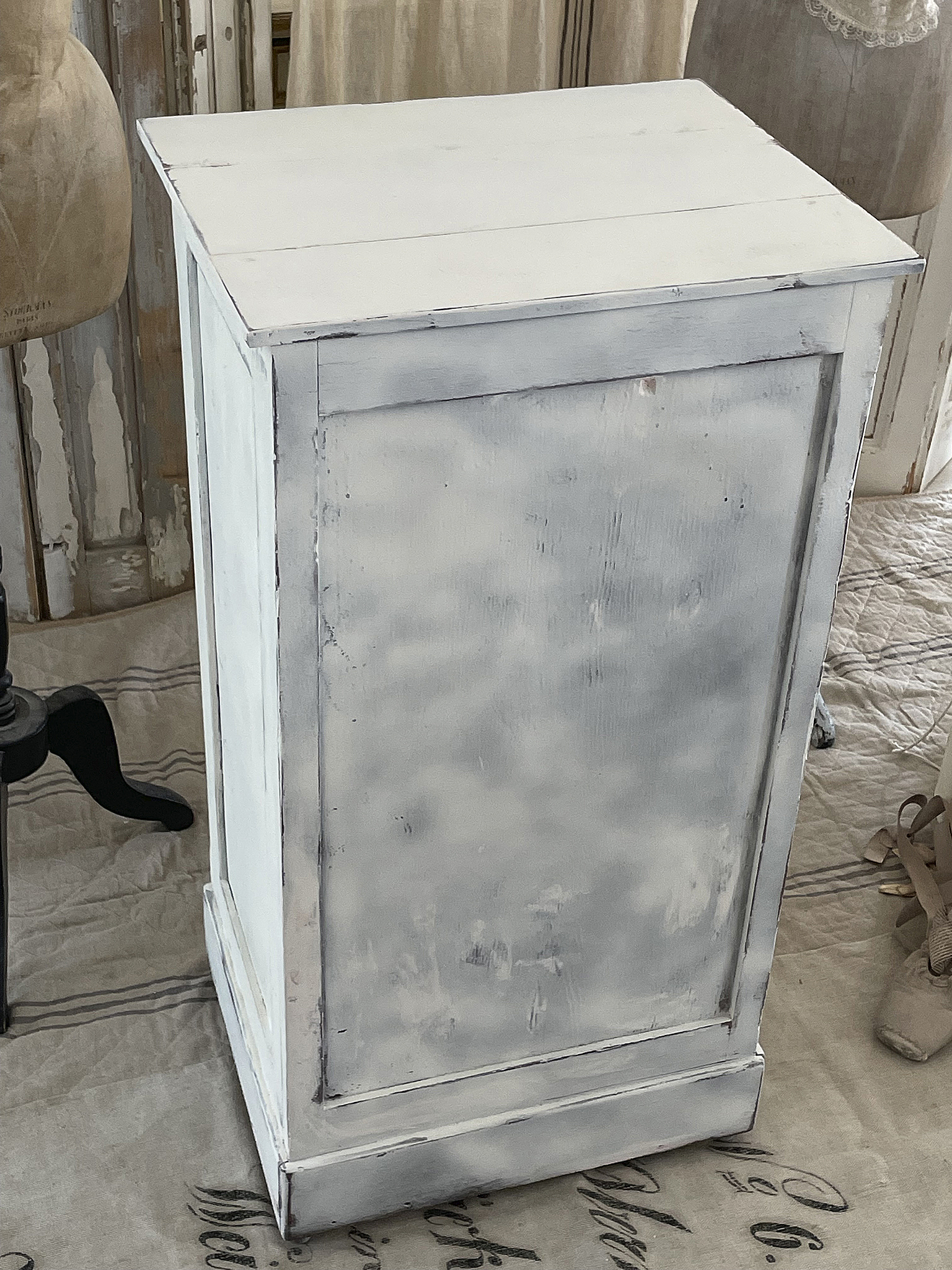 Vintage Kommode in Weiß mit antikem Finish Schlichte weiße Kommode mit leicht abgenutztem Look auf einem dekorativen Untergrund