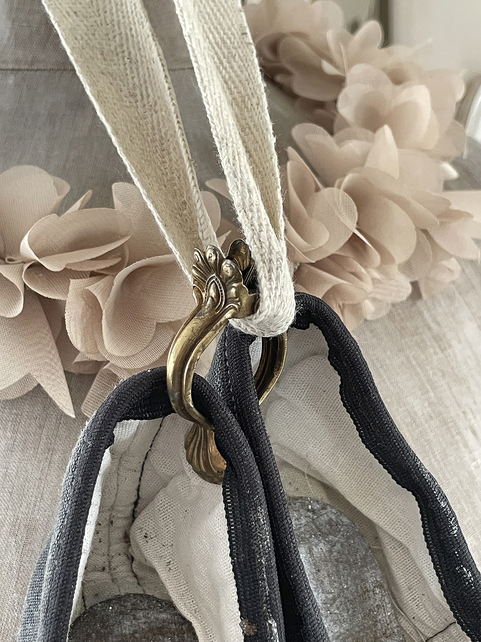 Handgemachte Tasche mit dekorativen Trägern und Verschluss Detailansicht einer handgemachten Tasche mit schwarzen und weißen Trägern und einem dekorativen Verschluss in Gold