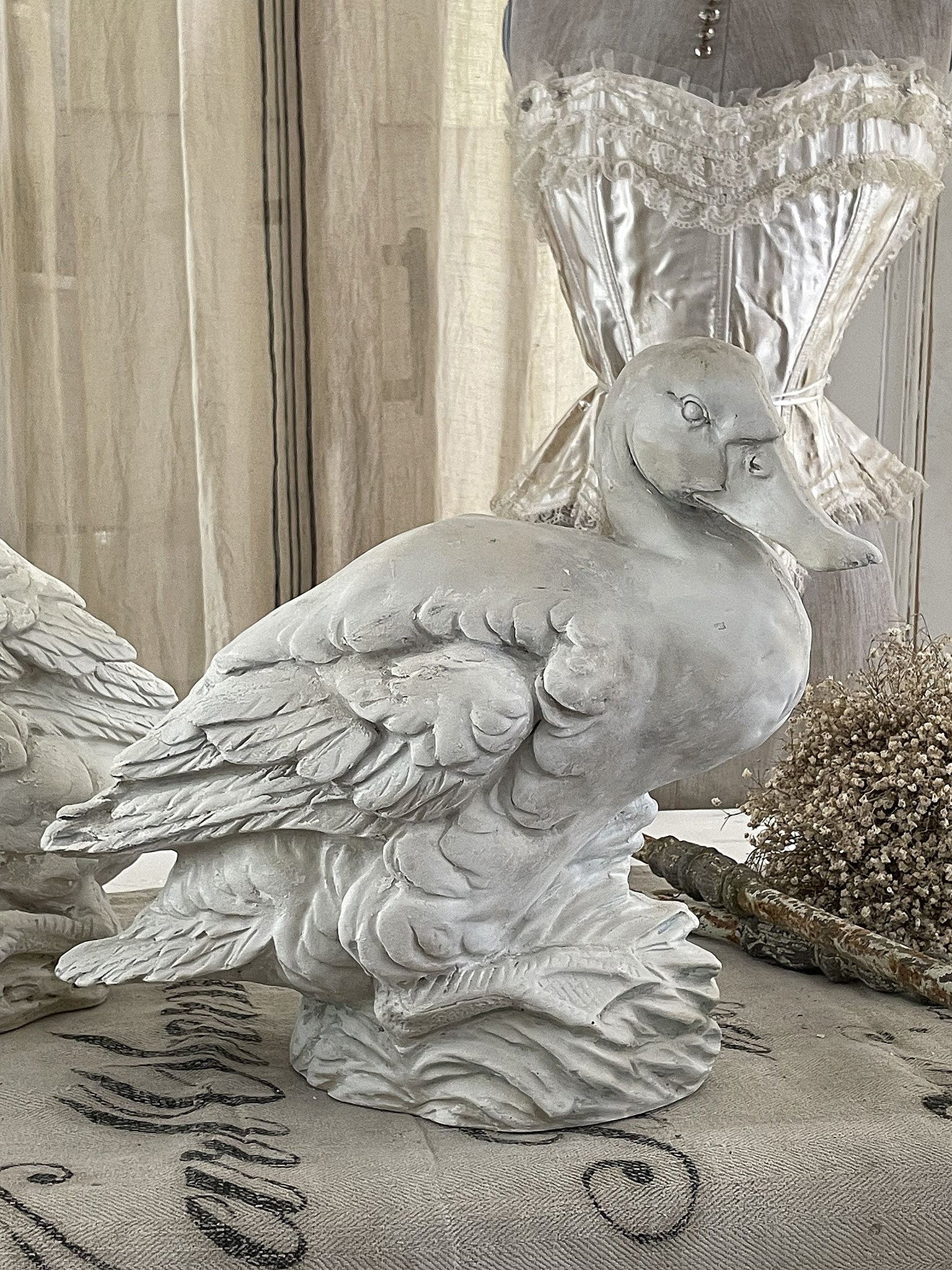 Weißer Gänsefigur aus Keramik auf einem Tisch in einem stilvollen Raum