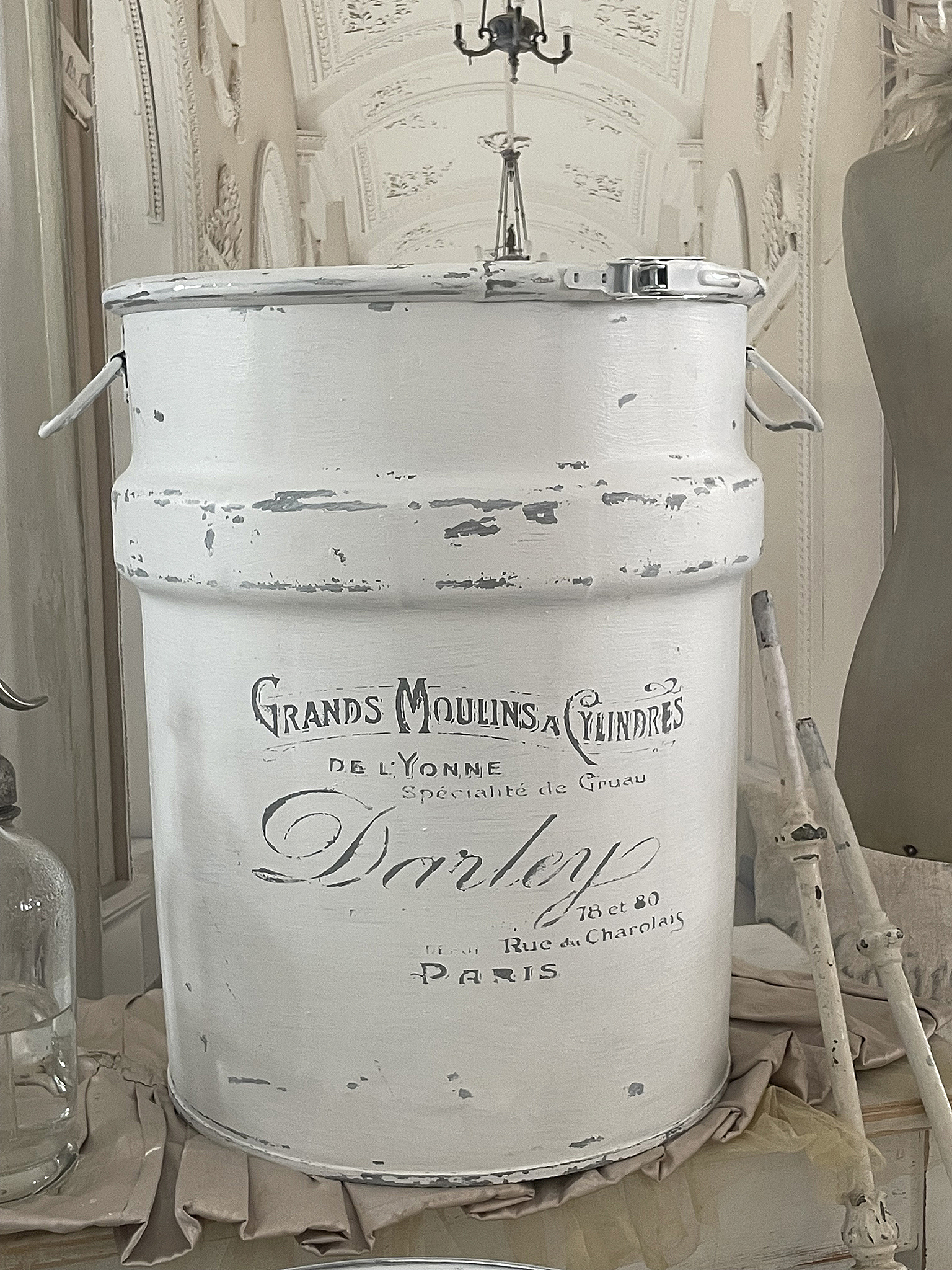Weiße Vintage-Milchkanne mit der Aufschrift Grands Moulins à Cylindres de l'Yonne, Paris, als dekoratives Element.