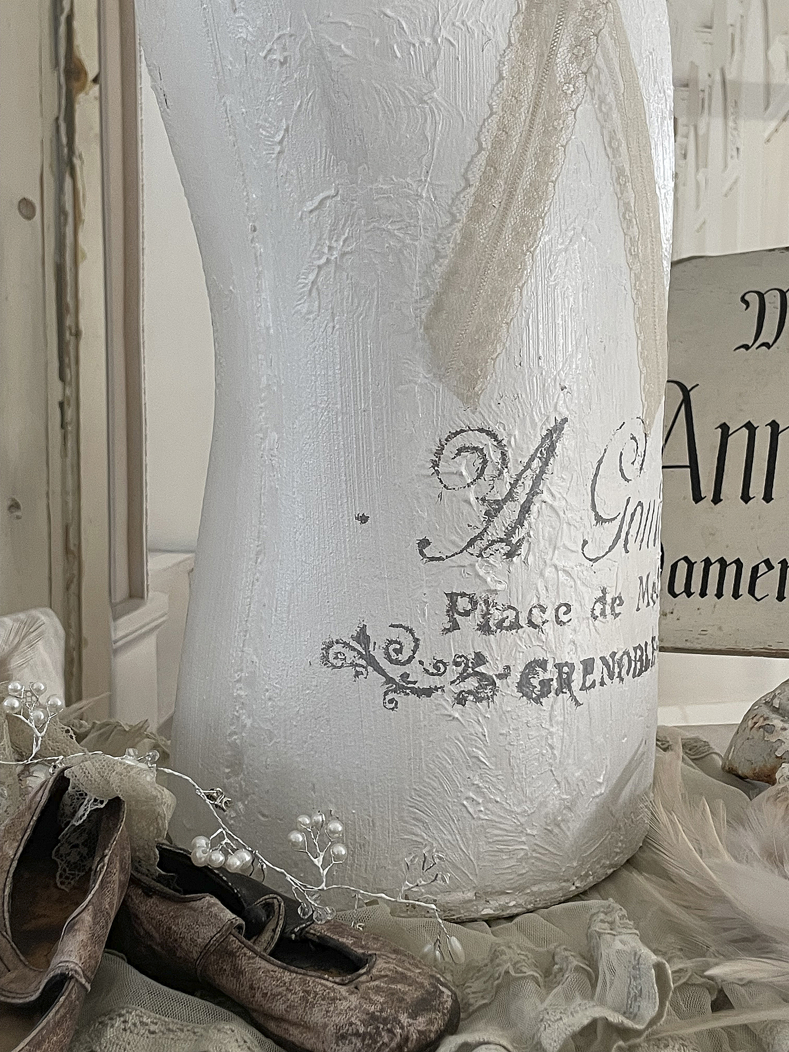 Weißer Kleiderständer mit vintage Design und dekorativen Accessoires Vintage Kleiderständer in Weiß mit Schriftzug und braunen Schuhen, stilvolle Dekoration