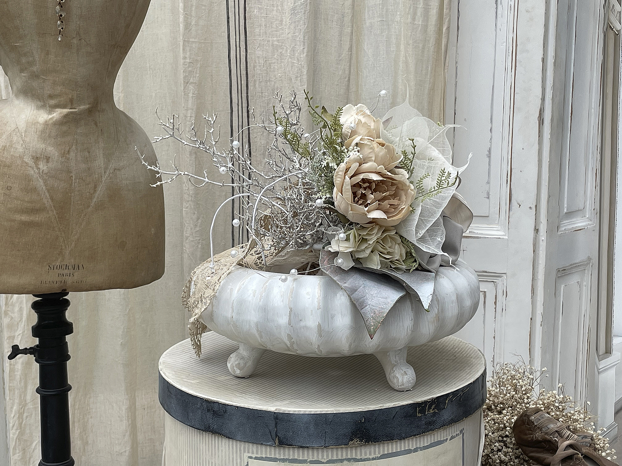 Elegantes Blumenarrangement mit zarten Farben in einer stilvollen Schale auf einem Tisch