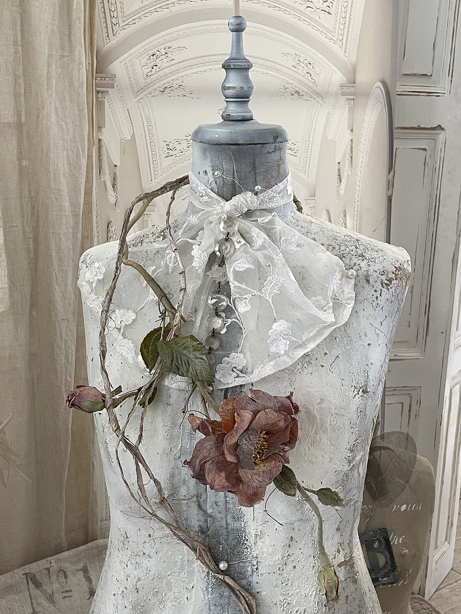 Elegante Dekoration für Kleiderständer mit Spitze und Trockenblumen Kleiderständer mit schwarzer Spitze, Trockenblumen und Ranken in einem stilvollen Ambiente