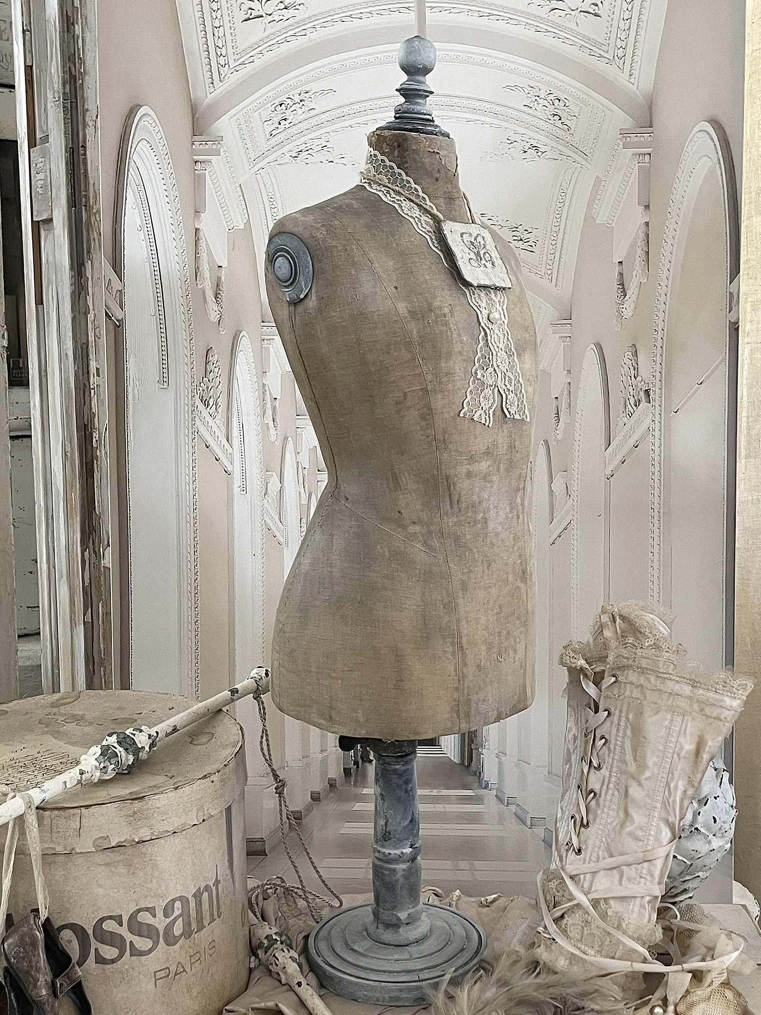 Vintage Schneiderpuppen-Dekoration mit Spitzenkragen und Korsett Antike Schneiderpuppe in einem eleganten Raum, umgeben von modischen Accessoires