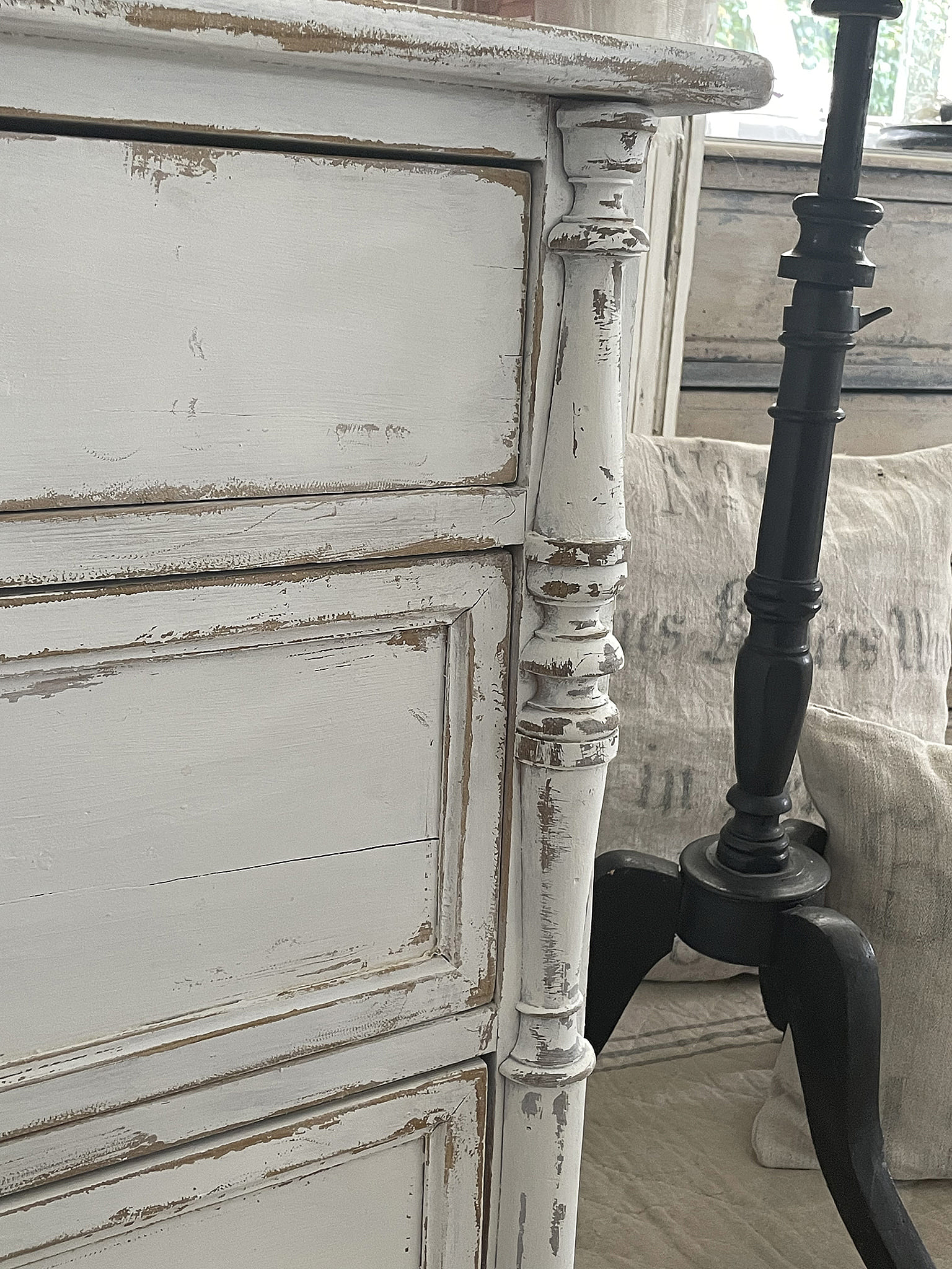 Detaillierte Ansicht einer vintage Kommode mit abgenutzter weißer Farbe und nostalgischem Charme.