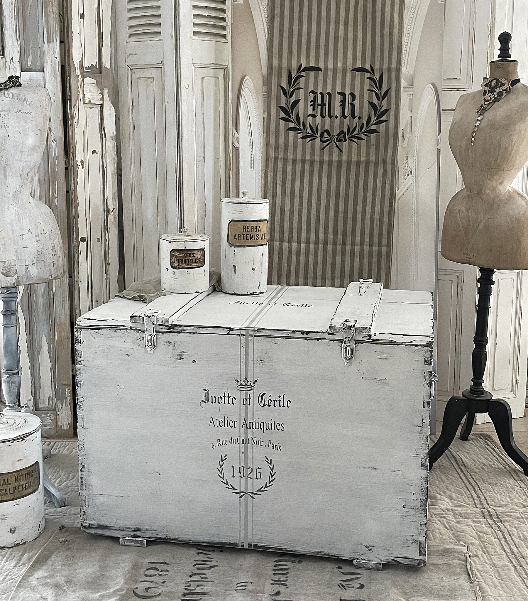 Antiquarische Truhe von Ivette et Cécile für stilvolle Inneneinrichtungen Vintage Truhe mit antiker Beschriftung in einem stilvollen Raum
