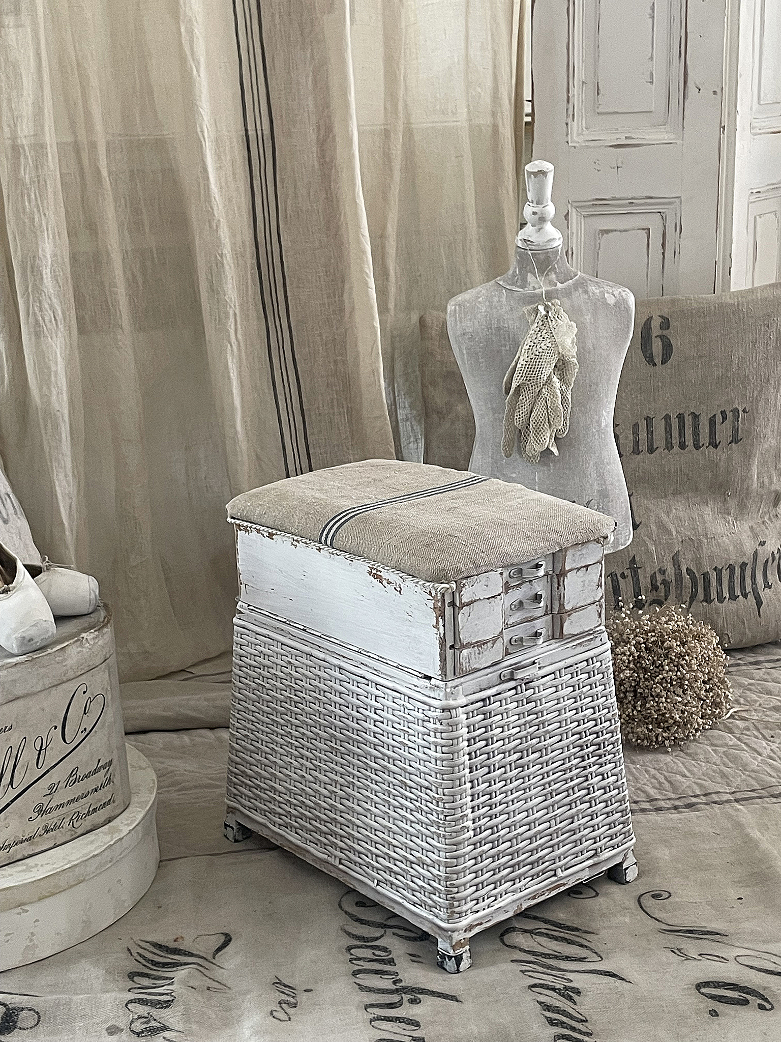 Eleganter Hocker im Vintage-Stil aus Rattan mit Polster Hochwertiger Hocker aus Rattan mit cremefarbener Polsterung in einem stilvollen Wohnambiente