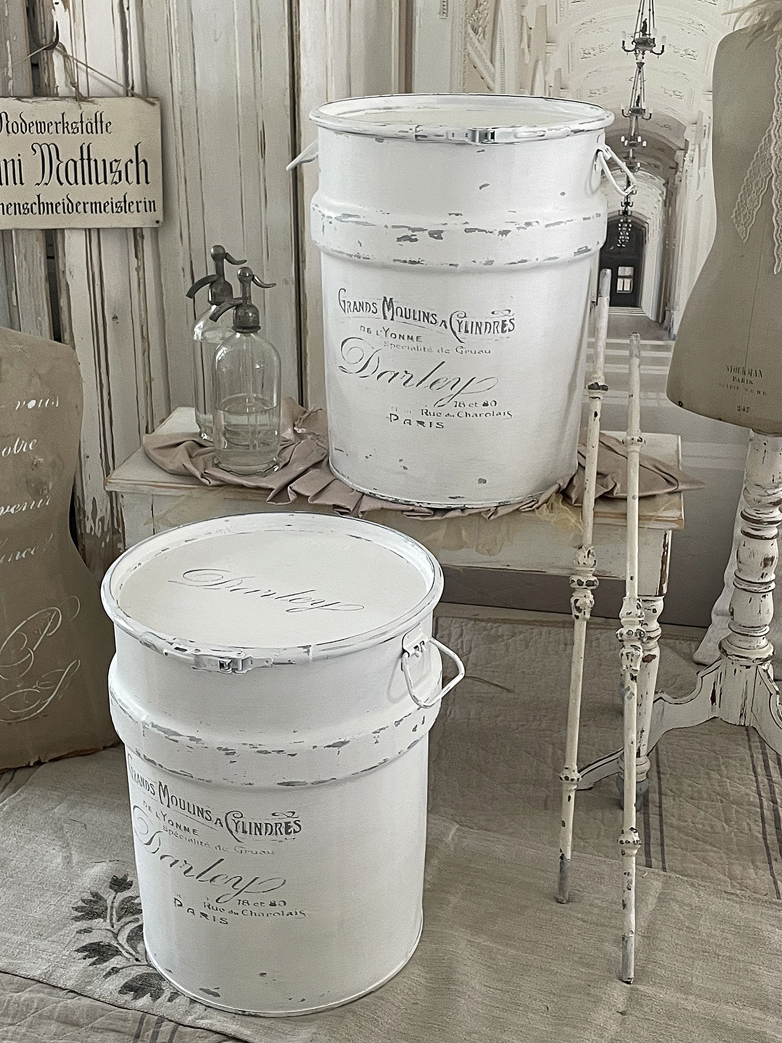 Zwei weiße Metallbehälter mit vintage Schriftzügen und nostalgischem Charme