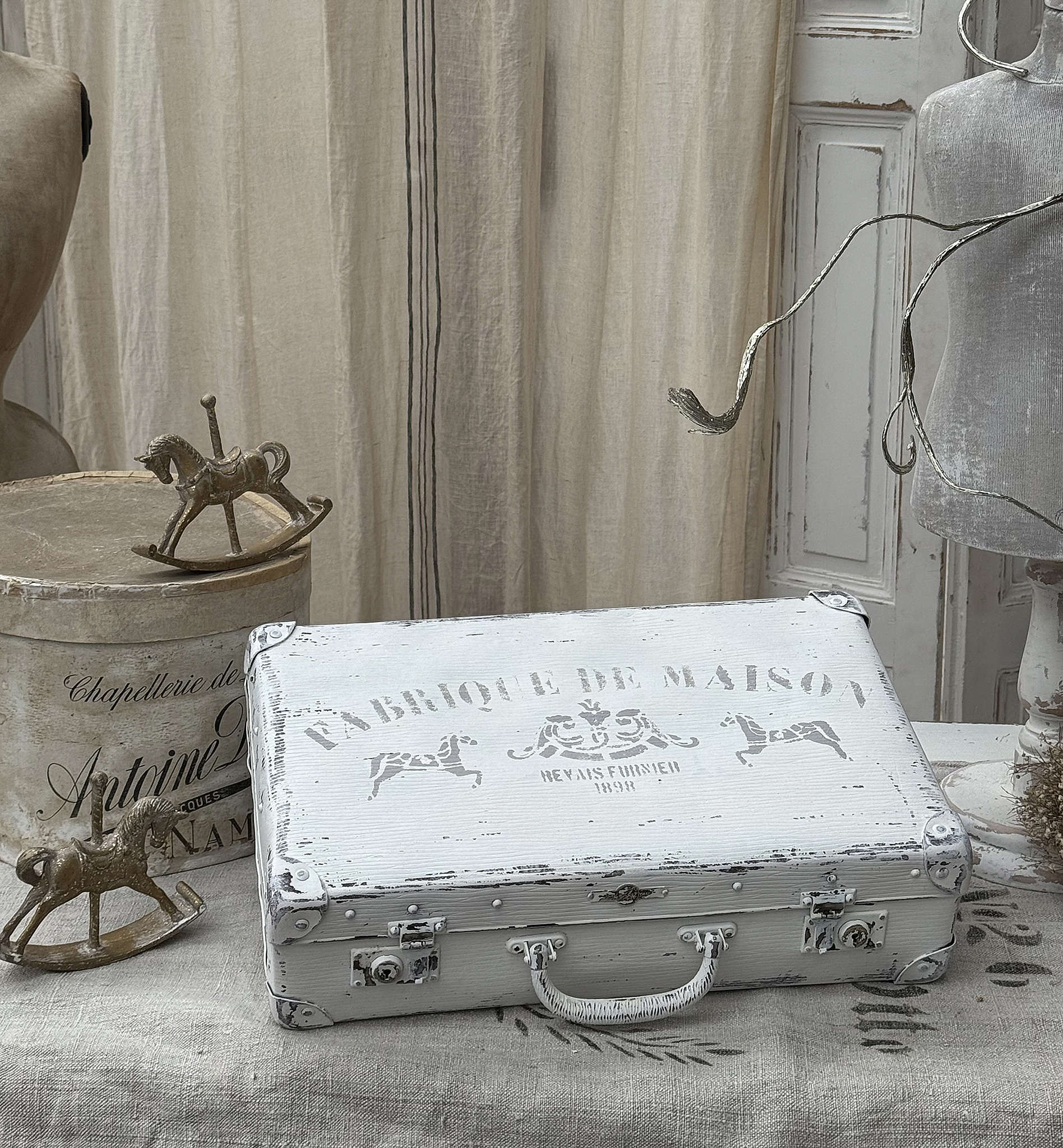 Vintage Koffer mit nostalgischem Design und dekorativen Elementen Antiker Koffer in Weiß mit Fabrique de Maison Aufdruck und nostalgischem Muster