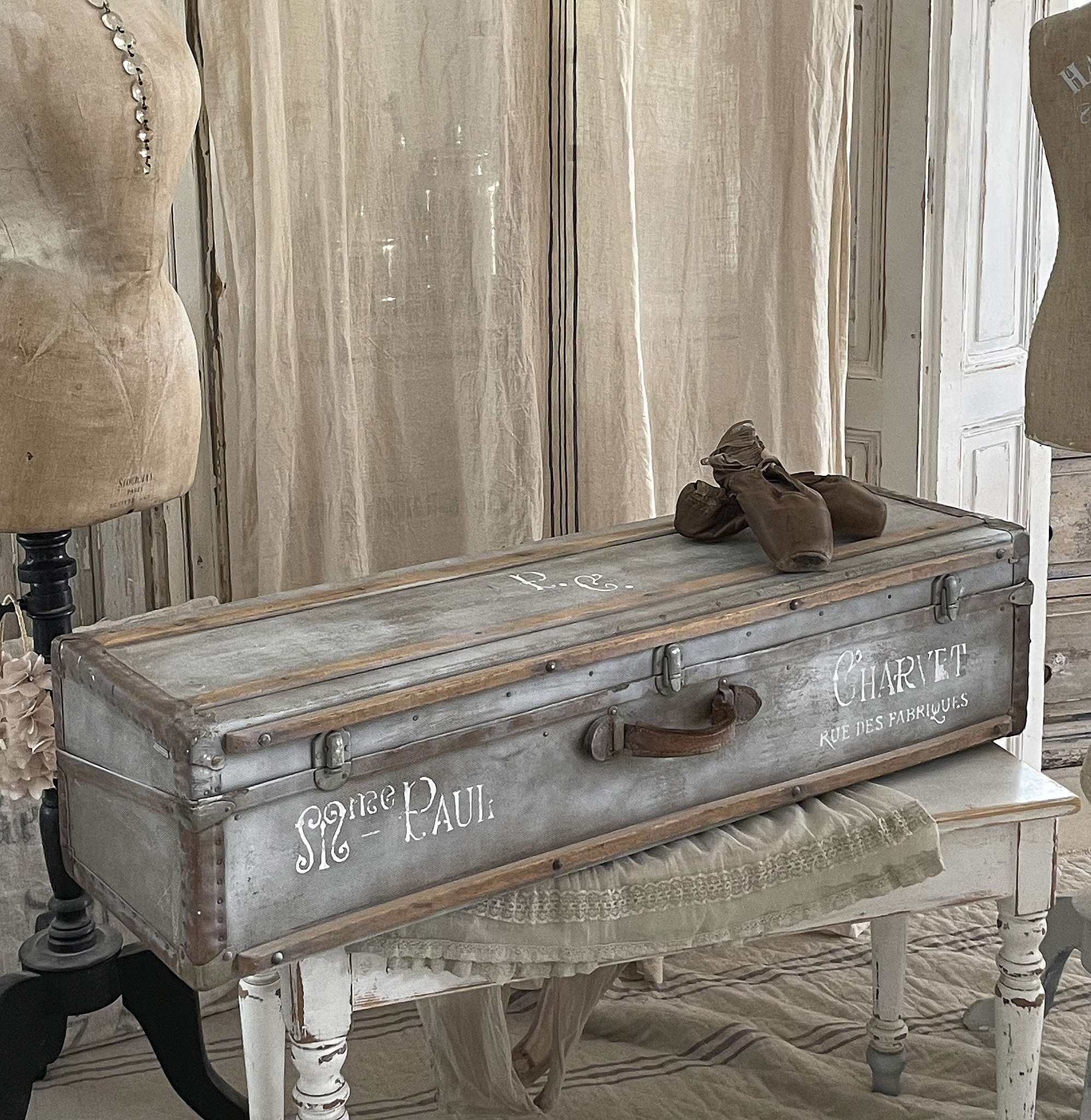 Antike Truhe mit Ballettschuhen und Schneiderpuppen Vintage Truhe mit dem Namen Paul, dekoriert mit Ballettschuhen und umgeben von Schneiderpuppen