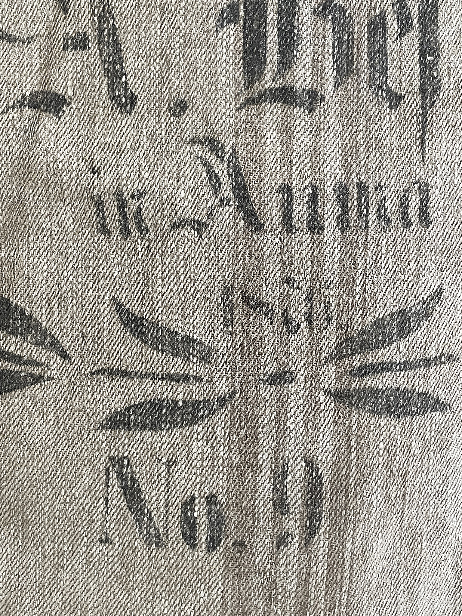 Detailansicht eines vintage Drucks auf Stoff mit Schriftzug und grafischen Elementen Nahaufnahme eines Stoffes mit alten Druckmotiven, darunter Schriftzüge und ornamentale Verzierungen