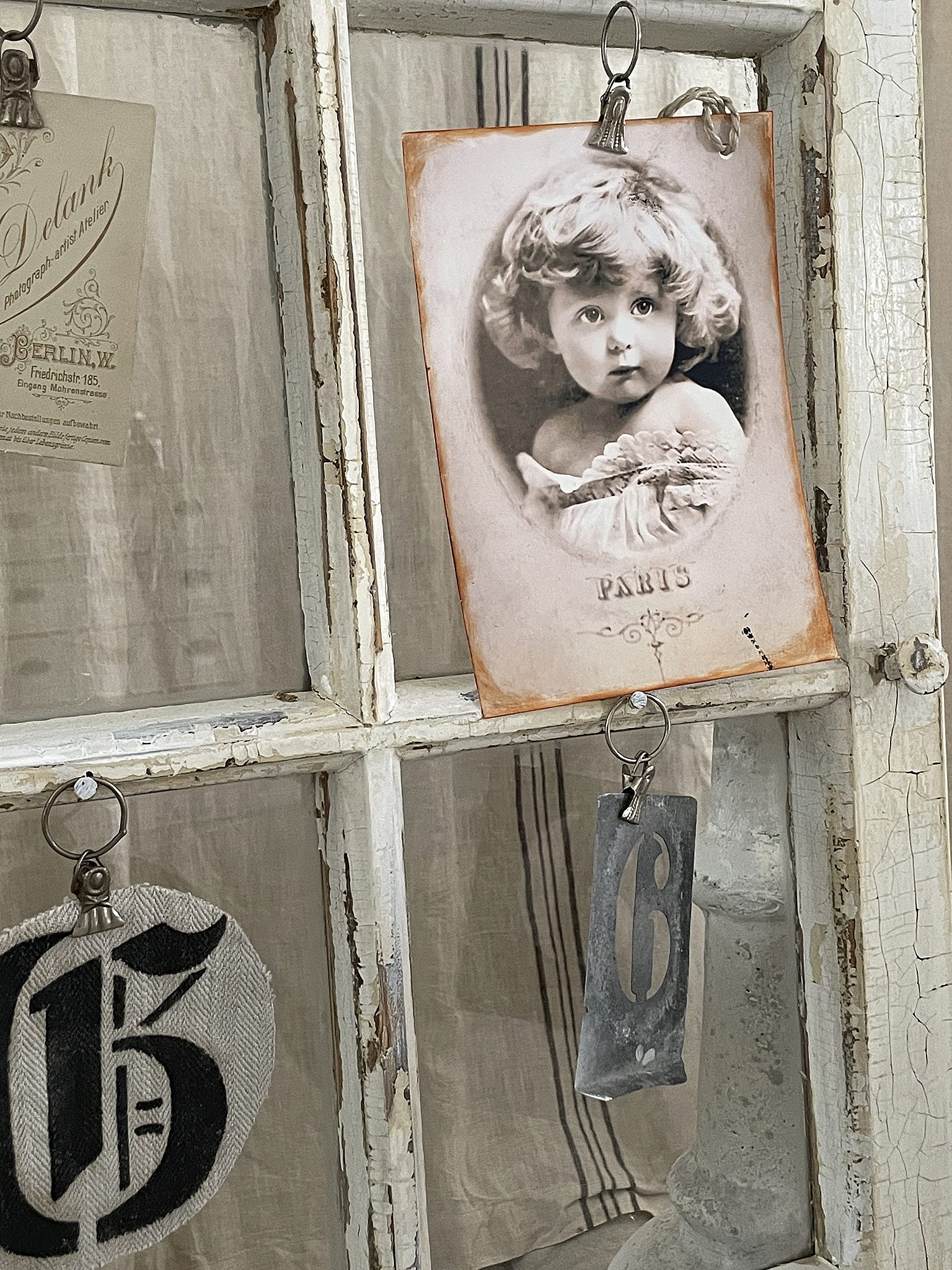 Vintage Fotografie eines Mädchens mit historischen Elementen Ein nostalgisches Bild eines Mädchens in einem antiken Rahmen, umgeben von Vintage-Objekten.