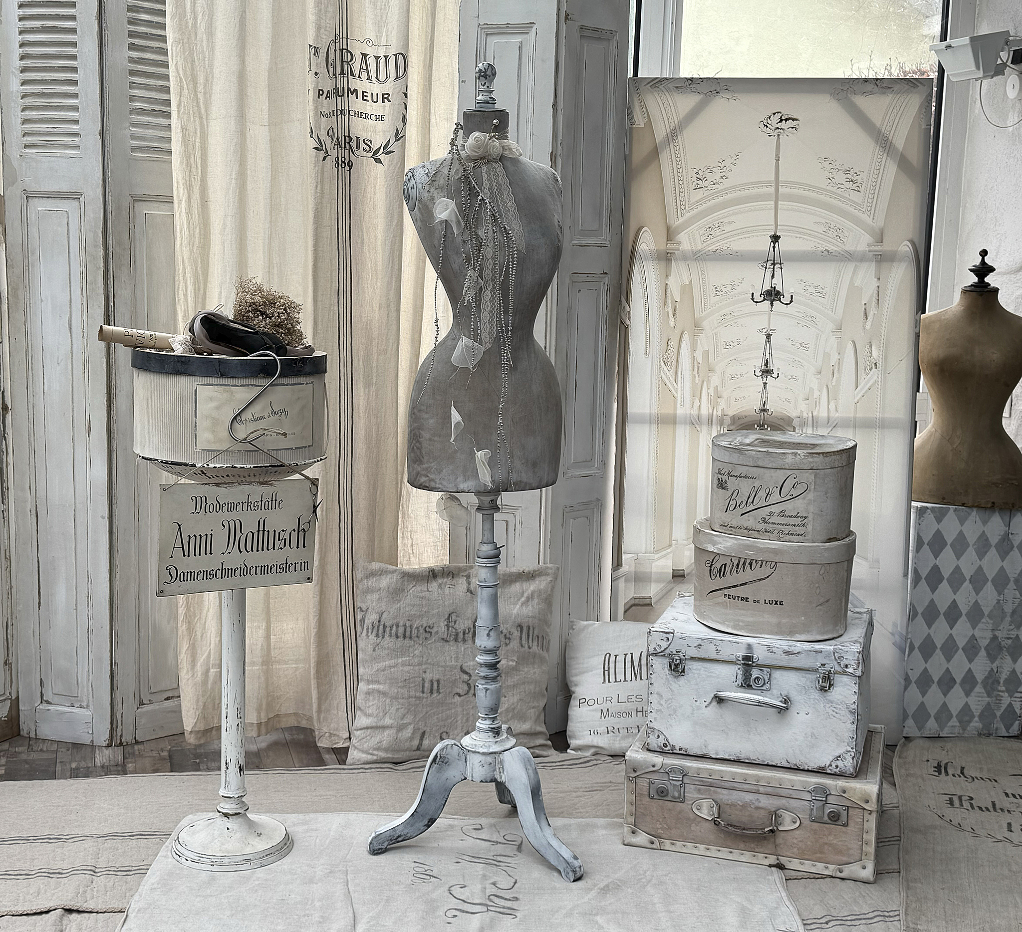 Schneiderpuppen und antike Boxen in einem stilvollen Raum mit vintage Dekoration