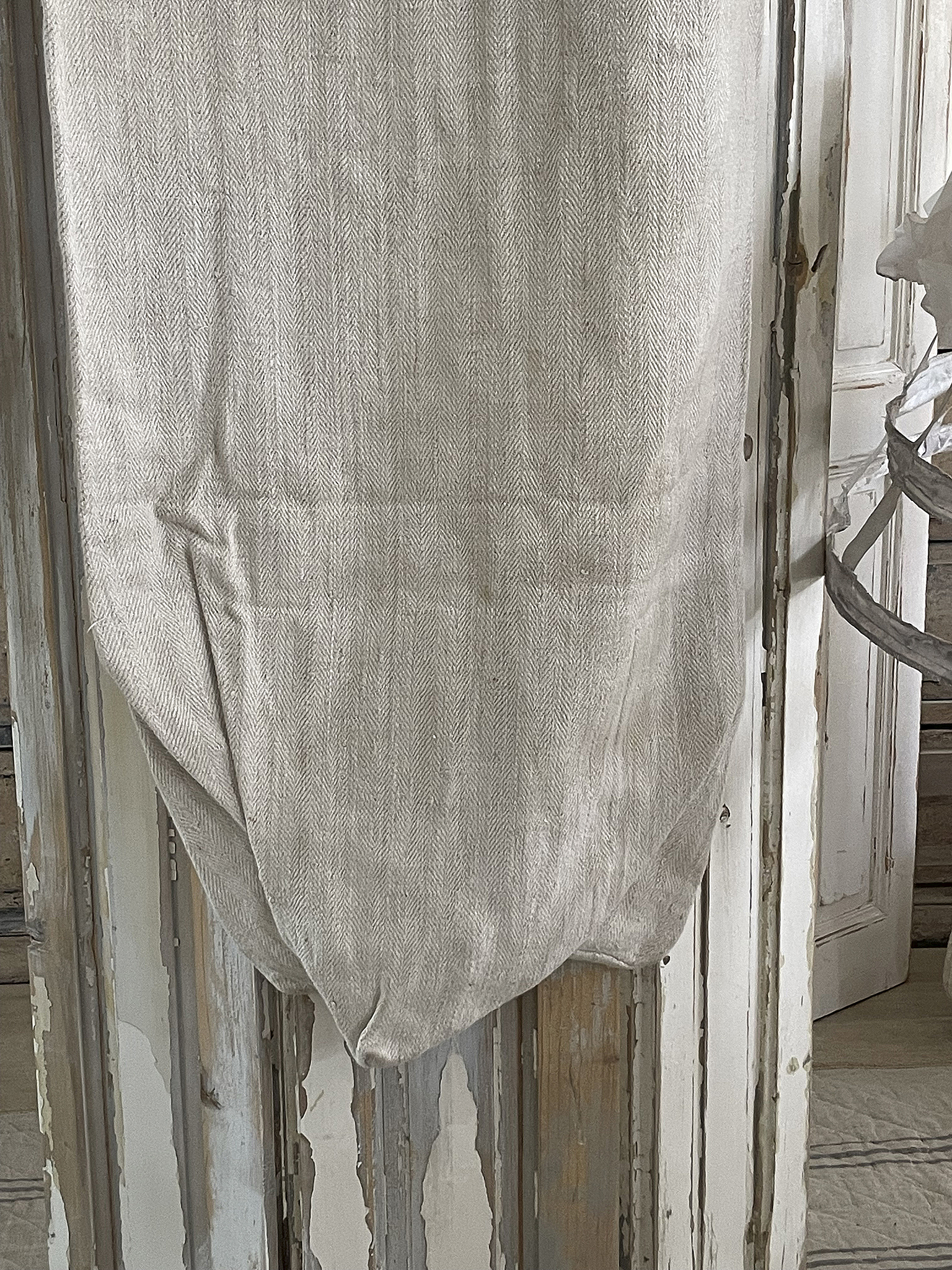 Leinenbeutel mit feinem Herringbone-Muster, hängend an einer Wand