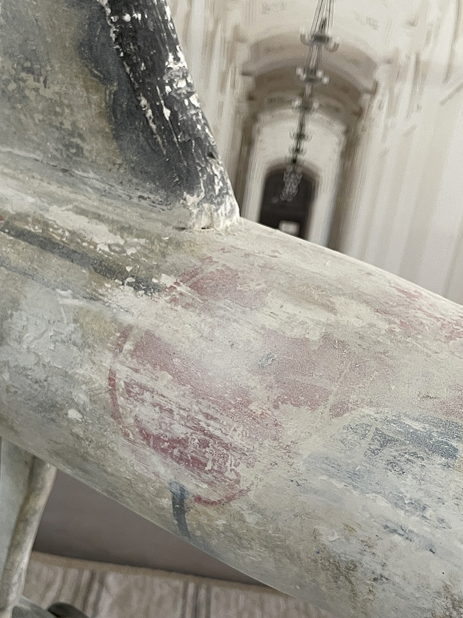 Detailaufnahme eines verzierten Geländers in einem historischen Gebäude Nahaufnahme eines verzierten Geländers mit Abnutzungsspuren und roten Markierungen in einem Innenraum